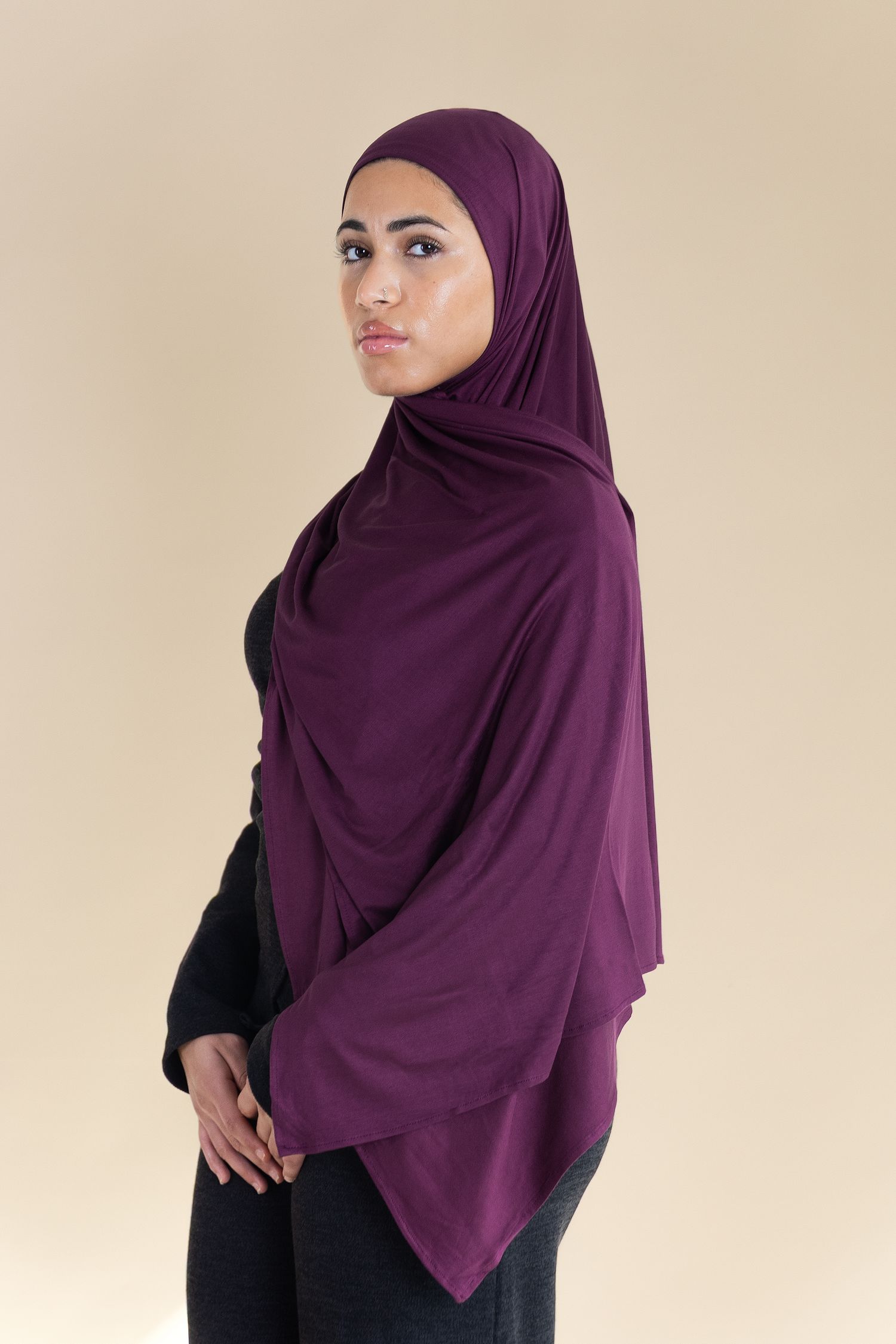 A purple hijab shown from four different angles against a beige background, displaying modest fashion styling.