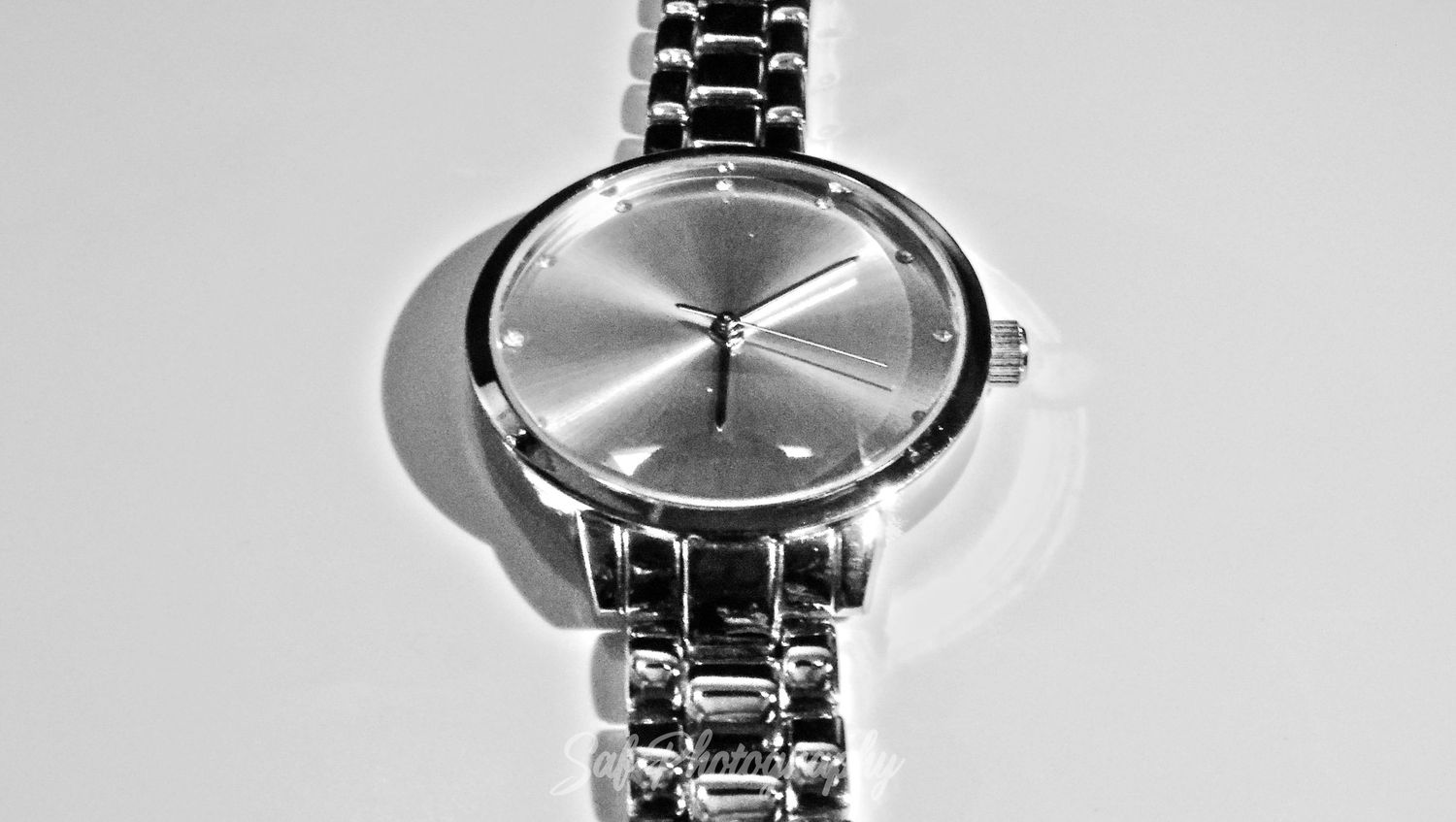 A collection of sleek silver wristwatches with metallic bands arranged in a row showing different modern designs and styles.