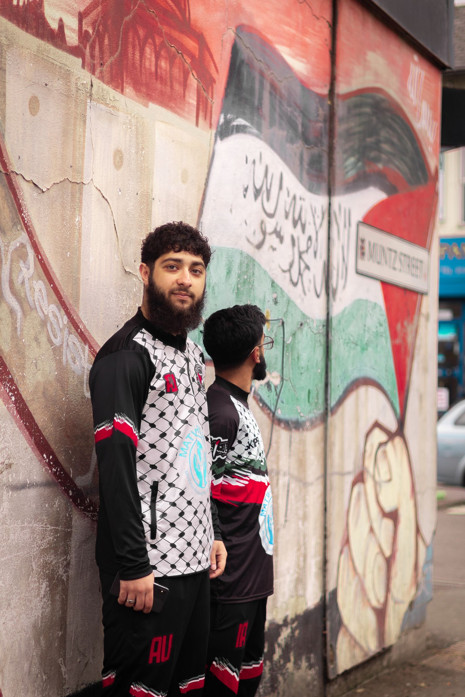 Soccer players in patterned uniforms posing against colorful graffiti wall.