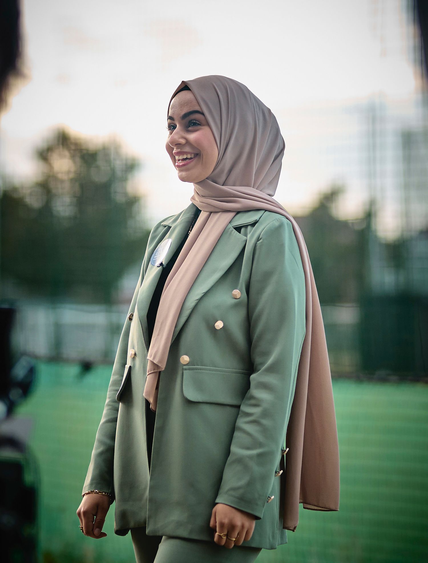 Outdoor fashion photography showcasing a mint green blazer suit with neutral accessories.
