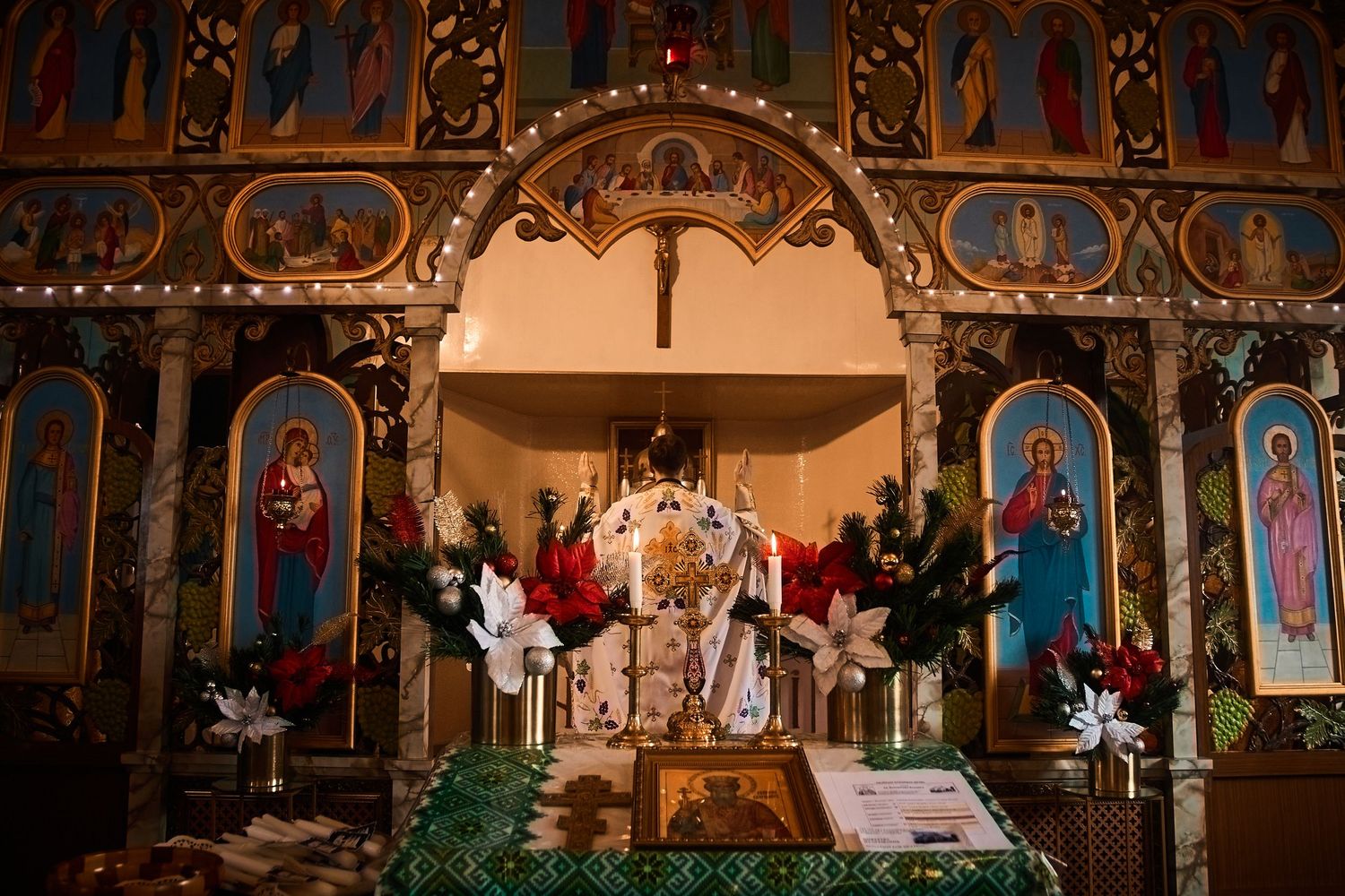Ornate Orthodox church sanctuary with traditional iconography and holiday decorations.