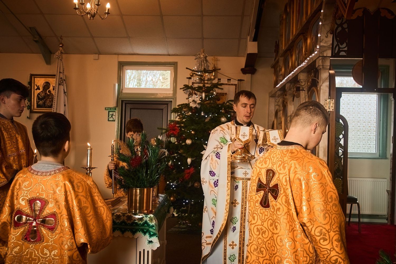 Religious ceremony in progress showing traditional Orthodox vestments and church interior.
