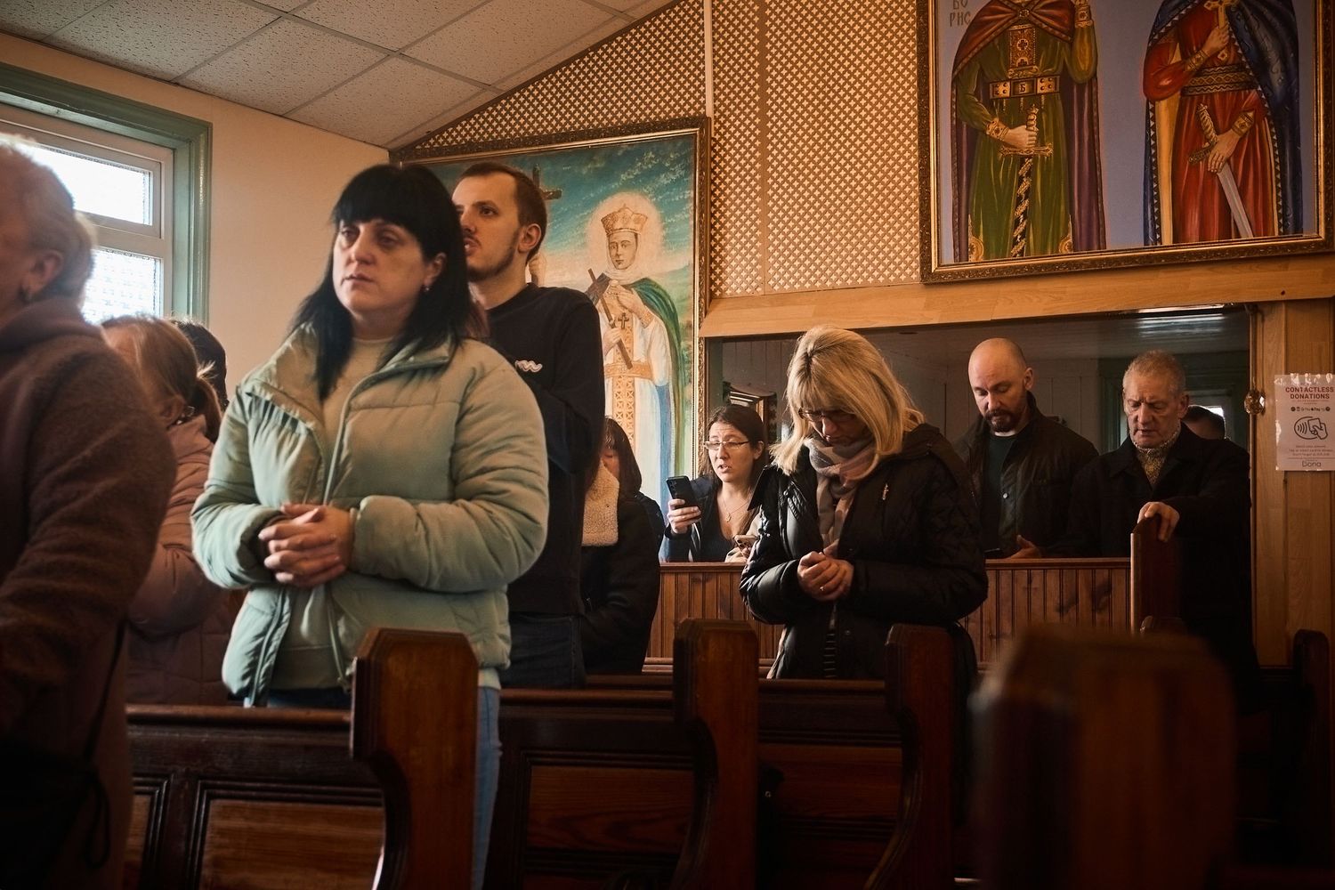 Church congregation seated in wooden pews during a holiday service.