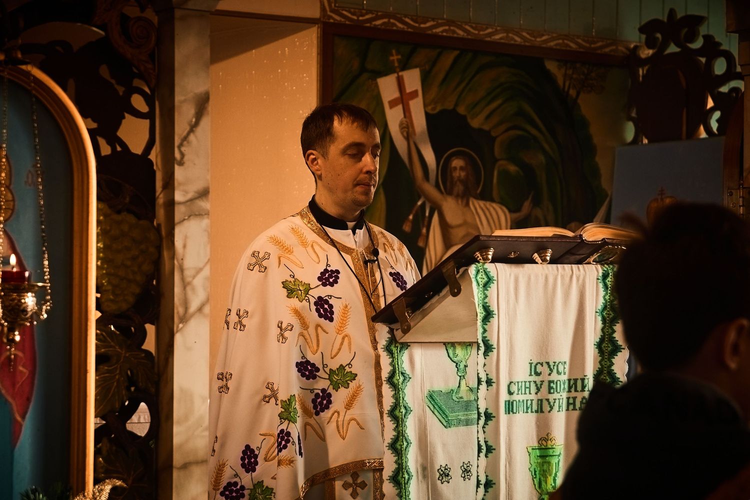 Clergy members in golden vestments conducting a religious ceremony in a decorated church.