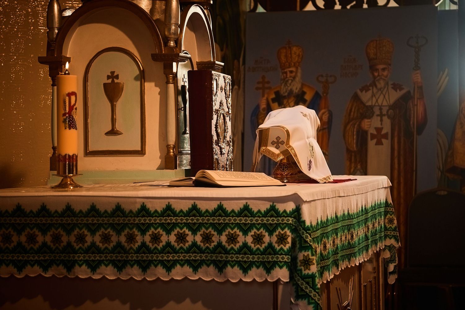 Orthodox clergy perform religious ceremony at altar decorated with ornate green and white altar cloths and religious icons.