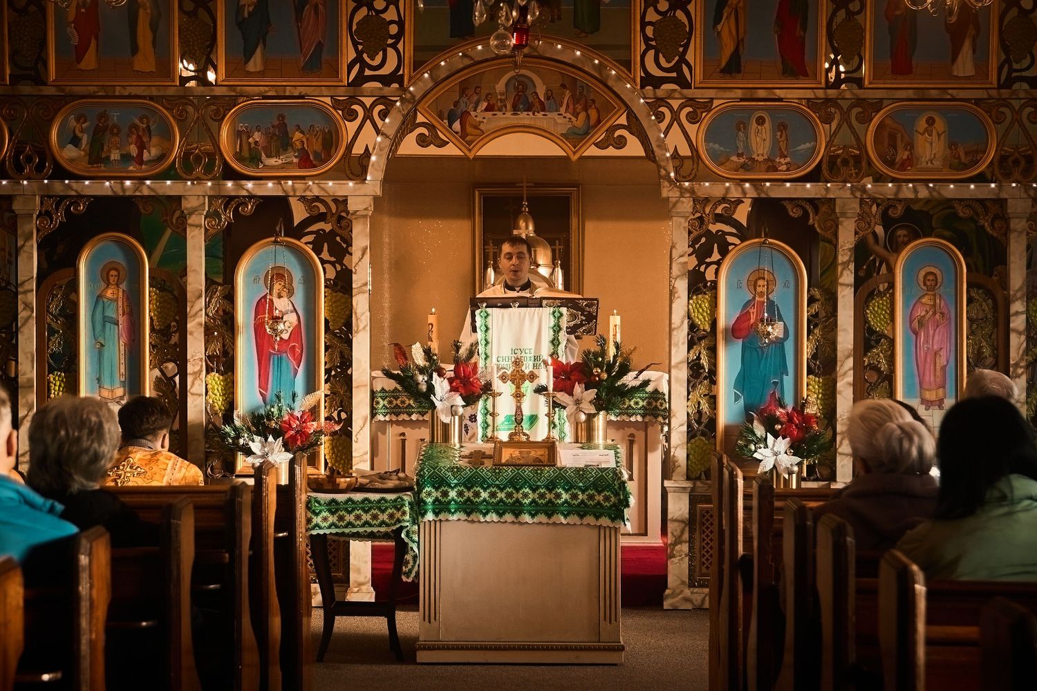 Wide view of an Orthodox church's ornate iconostasis with traditional religious paintings and decorative elements.