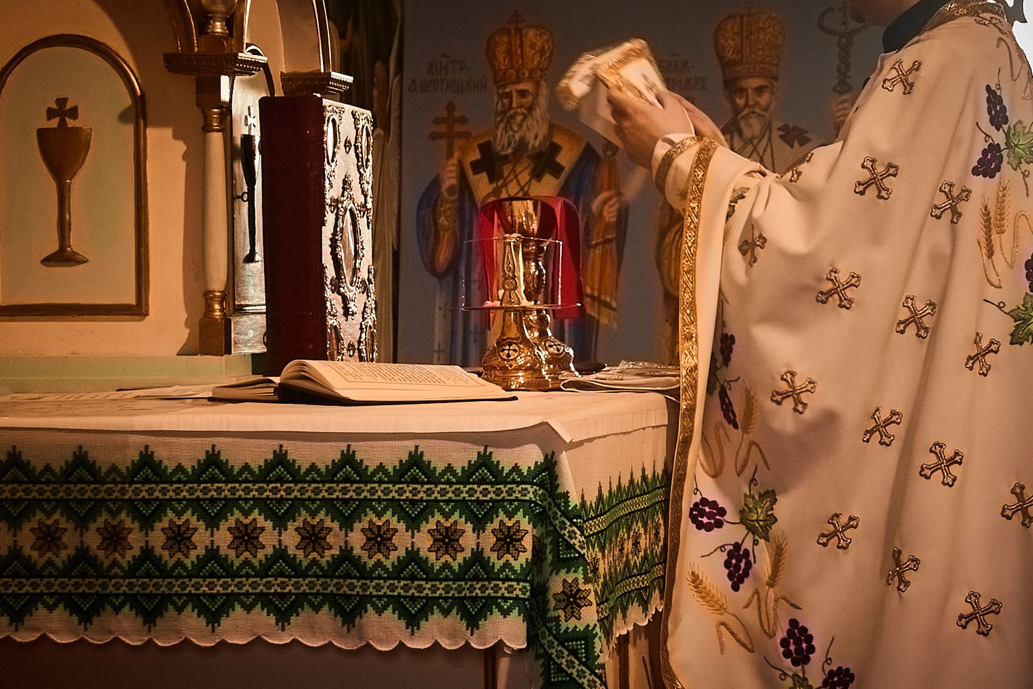 Religious altar decorated with ornate cloths and icons during Orthodox church ceremony.