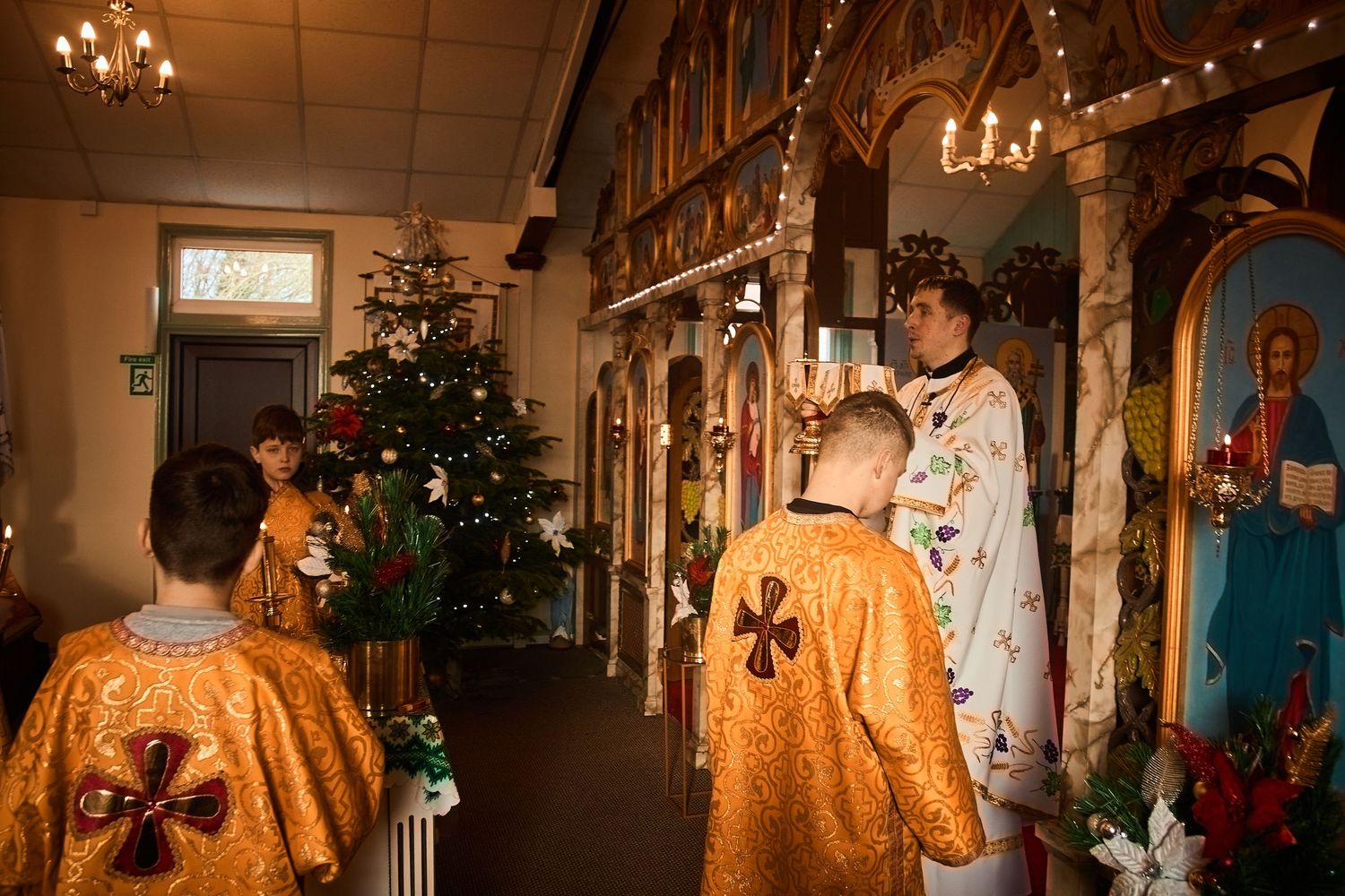 Orthodox liturgical service with gold vestments and traditional church decorations visible.