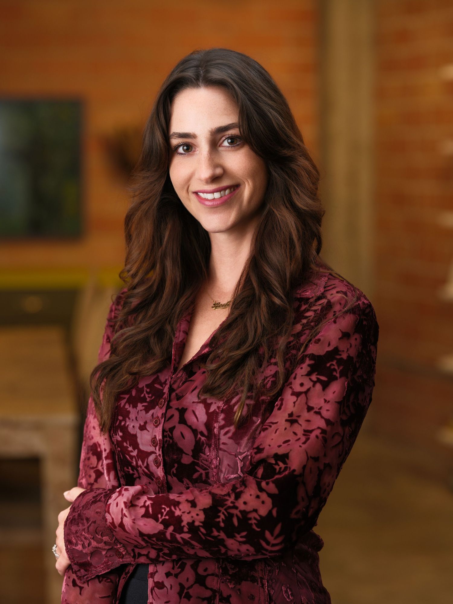 Portrait series of a person in burgundy velvet top against brick wall with natural lighting and dynamic poses.