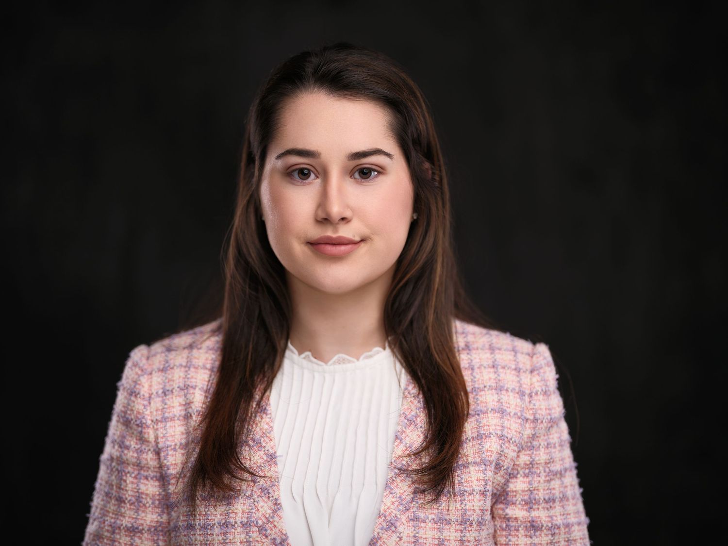 A sequence of headshot photos showing a person in a pink blazer and white blouse against a dark background.