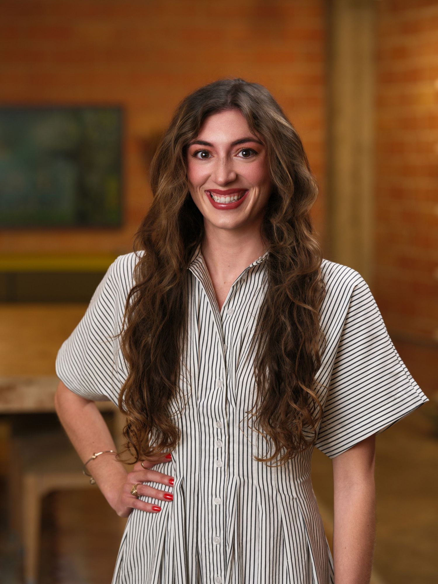 A creative headshot sequence showing different poses in a striped blouse against a warm wood-paneled backdrop.