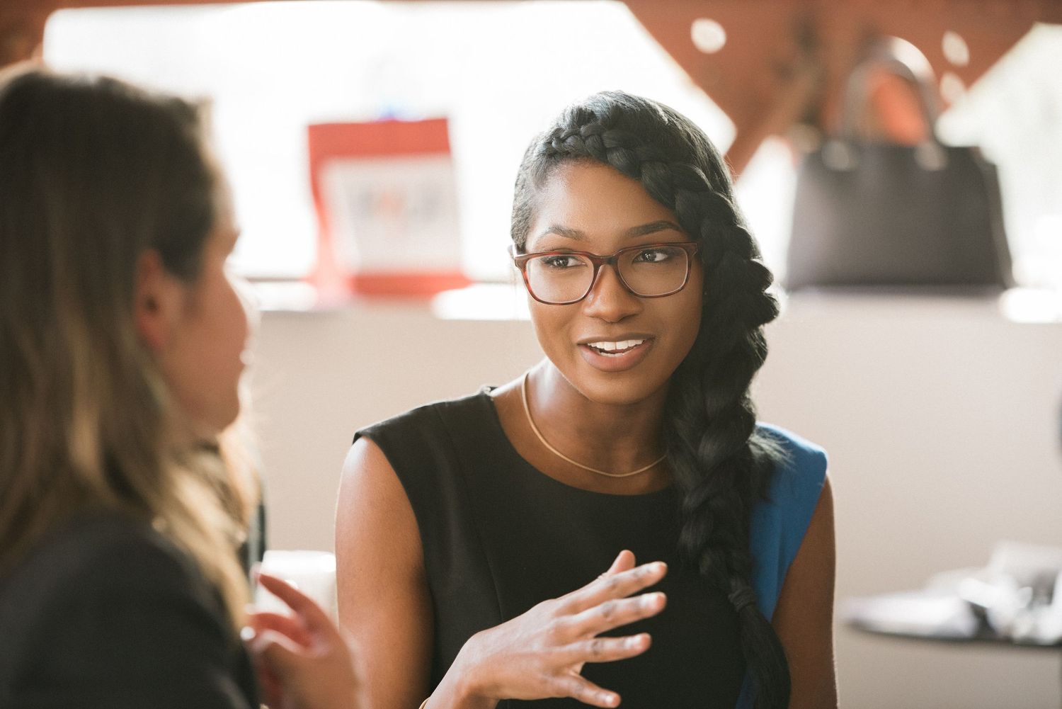 Two professionals engaged in animated conversation in a modern office setting.