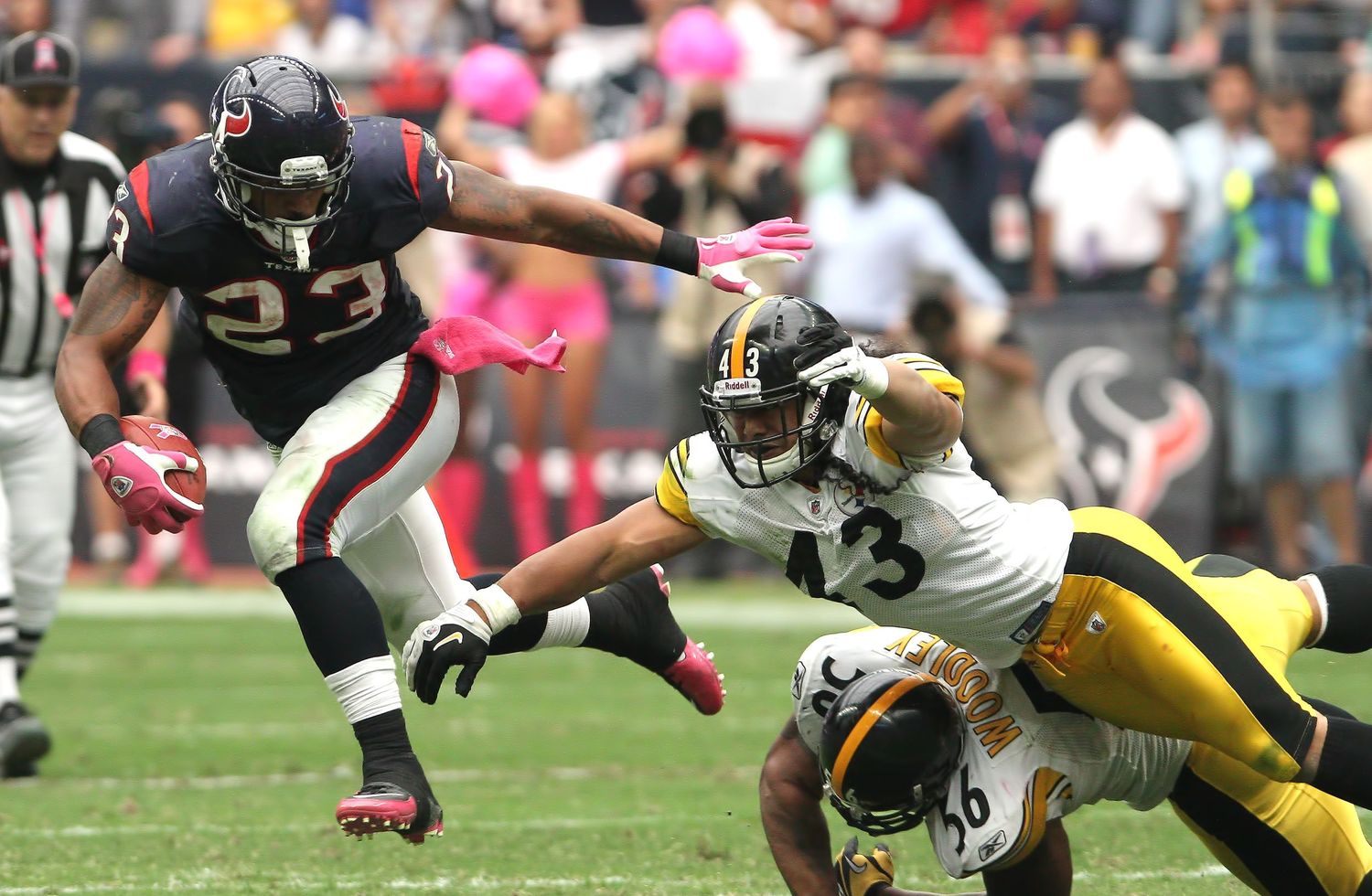 Running back evades tacklers during NFL game between Texans and Steelers.