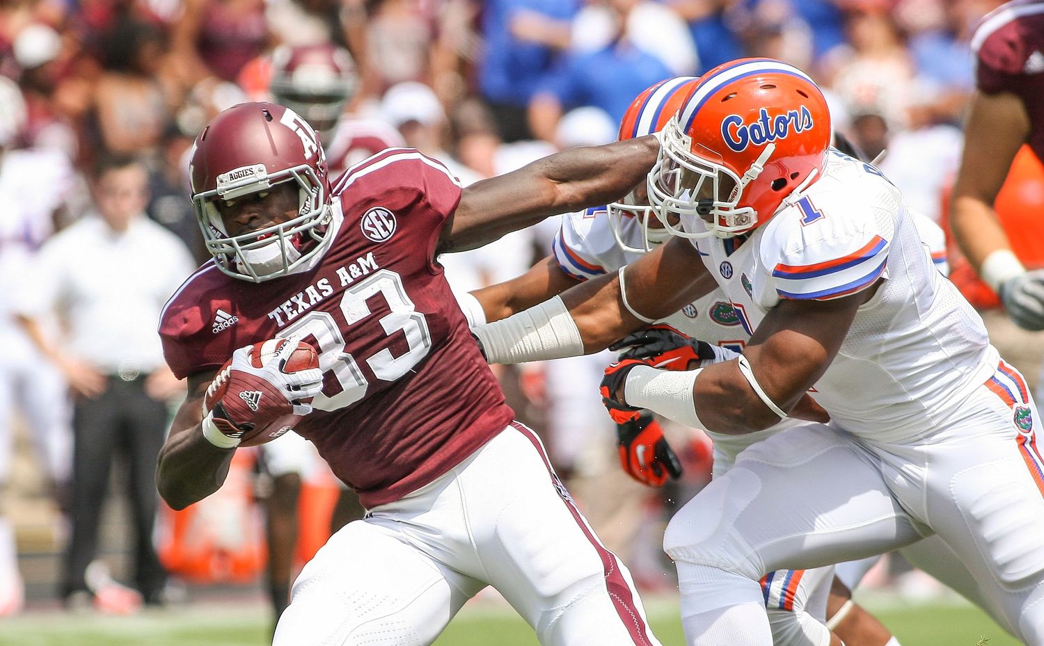 College football players from Alabama and Florida engage in intense defensive play during game.
