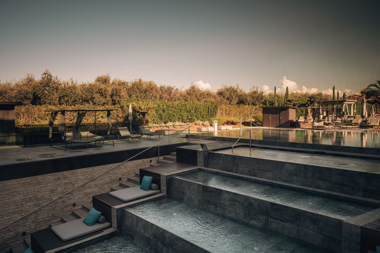 Outdoor swimming pool area with modern lounge chairs and desert landscape views.