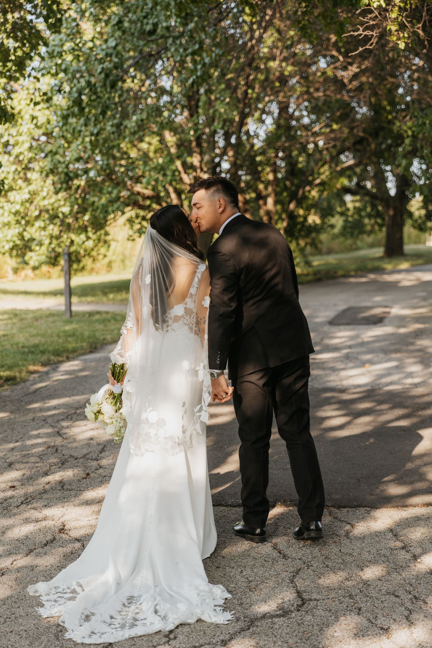 Bride and groom sharing a kiss outdoors after their wedding ceremony
