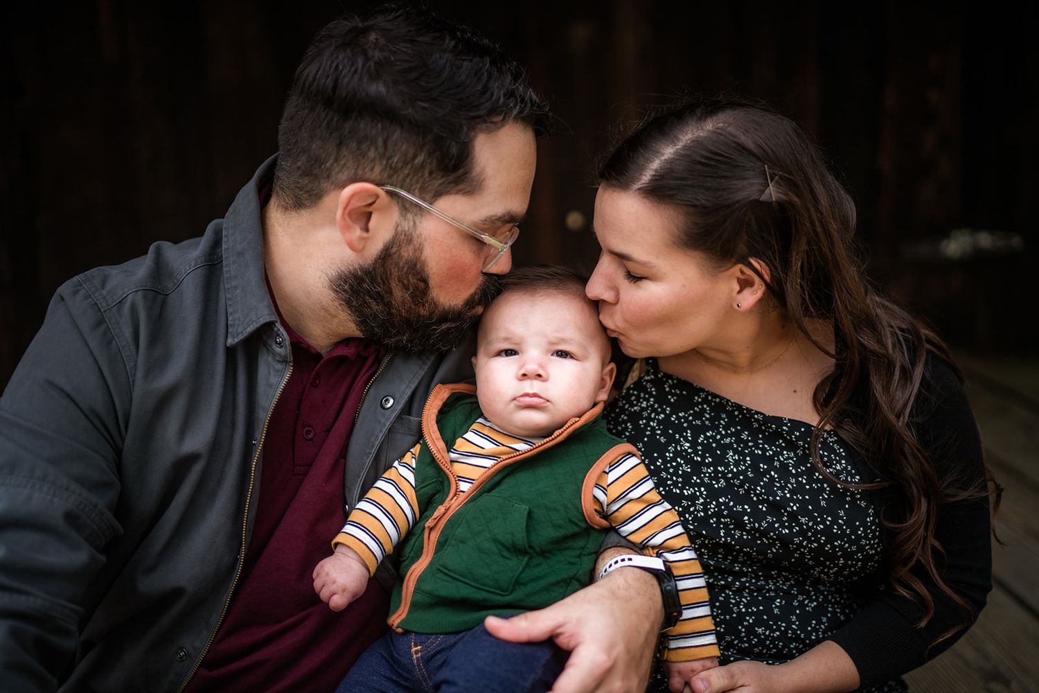 Intimate family moments captured in a series of dark, moody lifestyle portraits with gentle embraces and warm connection.