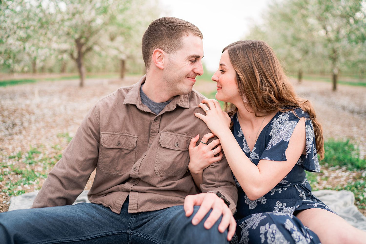 A couple shares tender moments while relaxing in a sunny outdoor setting.