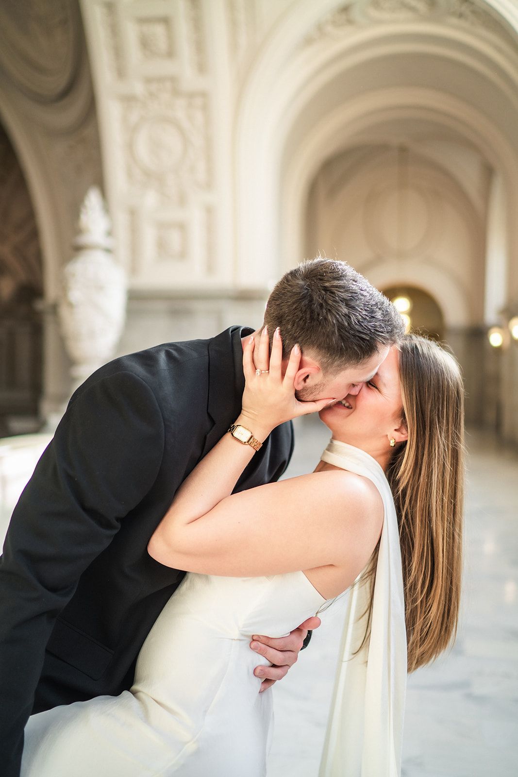 Romantic wedding portraits under ornate white archways in classical architecture.