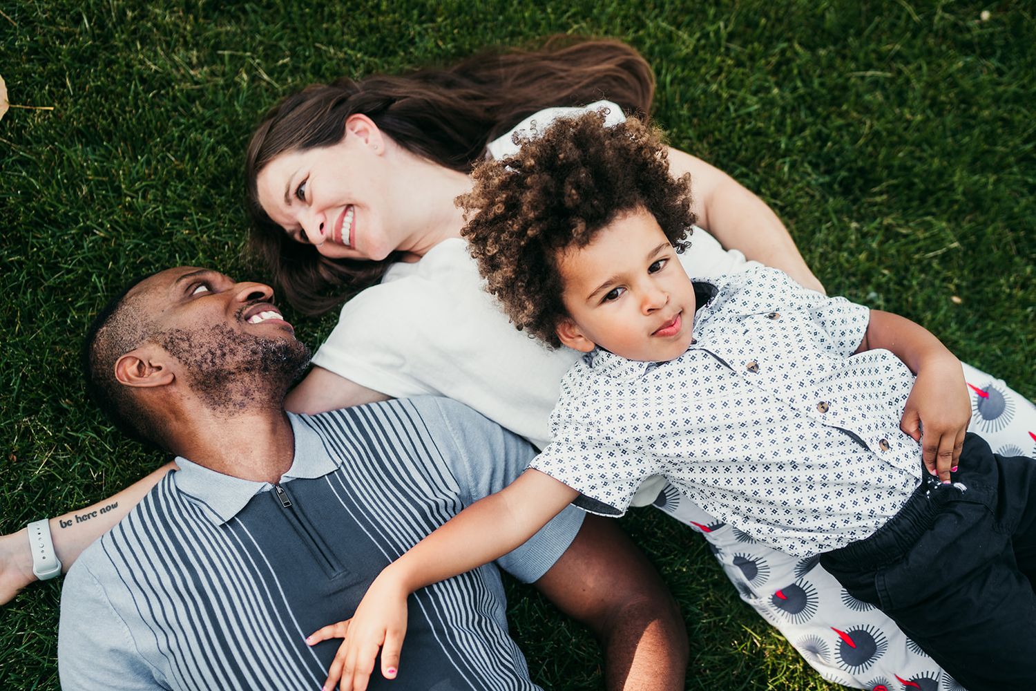 A series of candid outdoor photos showing people lying on grass and embracing in a park setting during summertime.