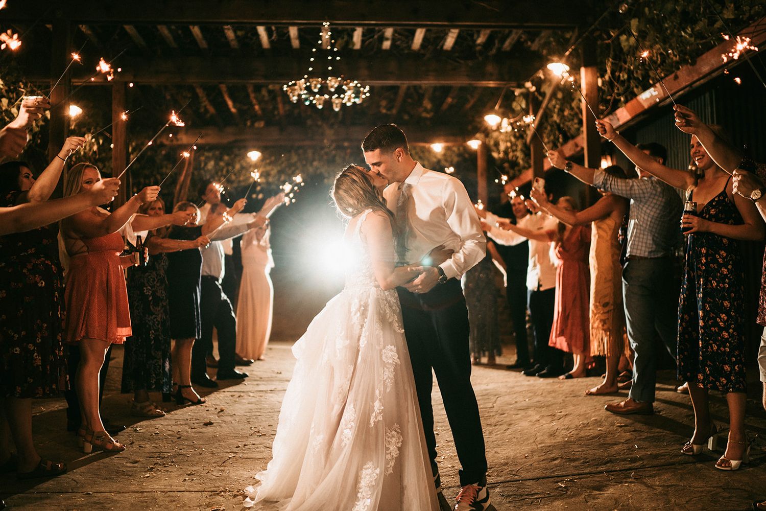 Wedding reception dance floor moments captured under warm lighting and chandeliers.