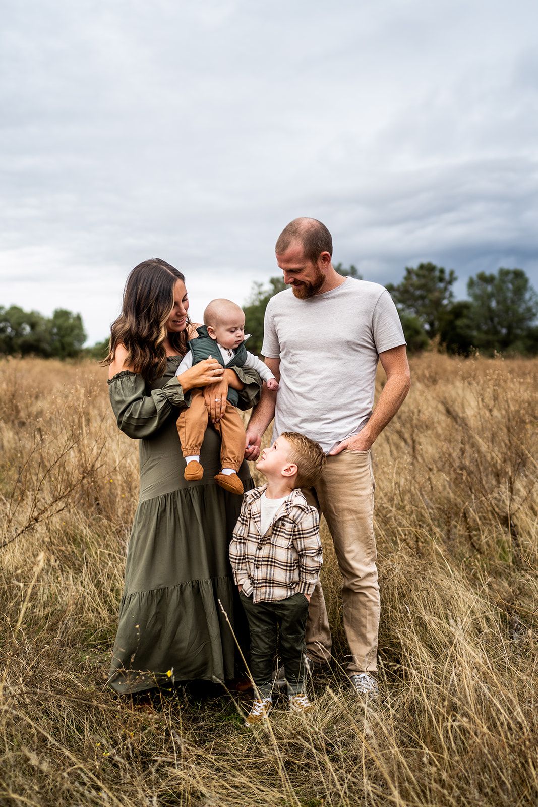 Family portrait session in a golden field during autumn.