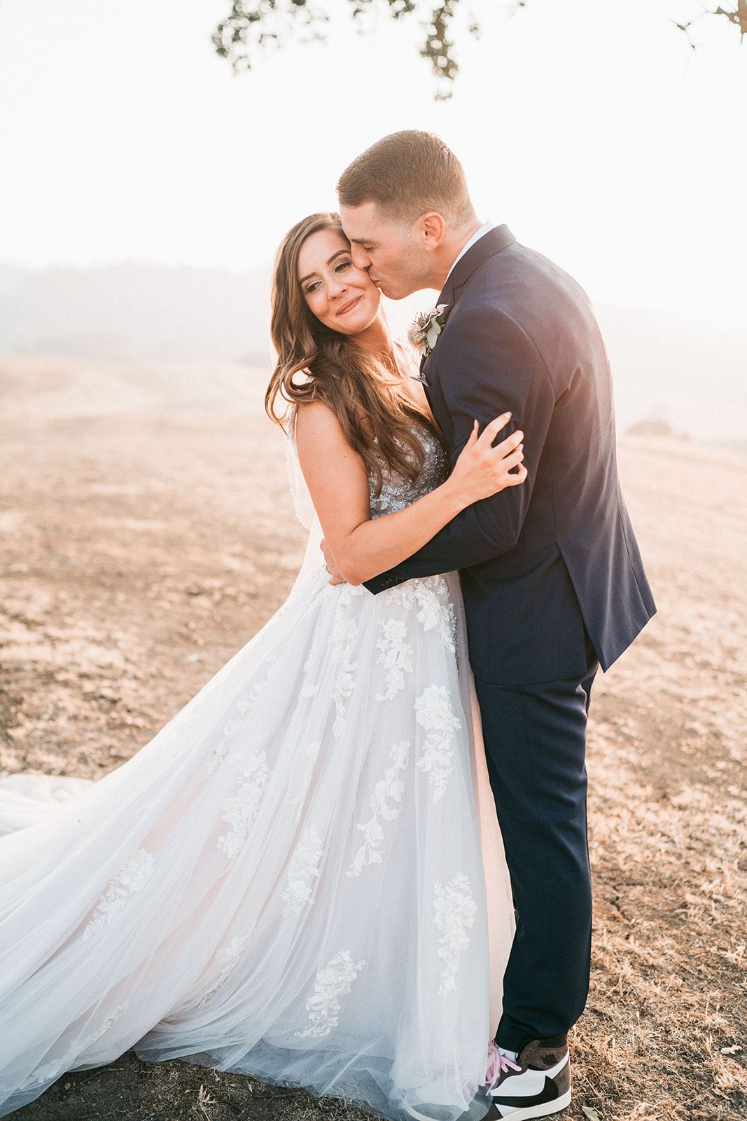 Romantic wedding portraits on a hillside with flowing white dress.