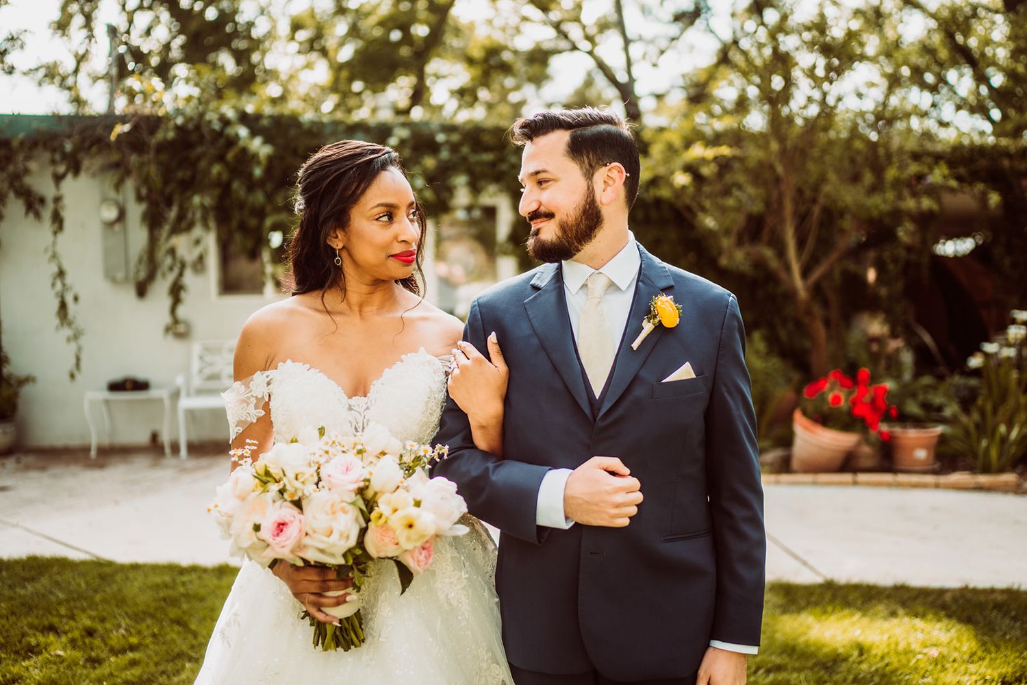 Romantic wedding portraits captured in soft golden light with floral arrangements.