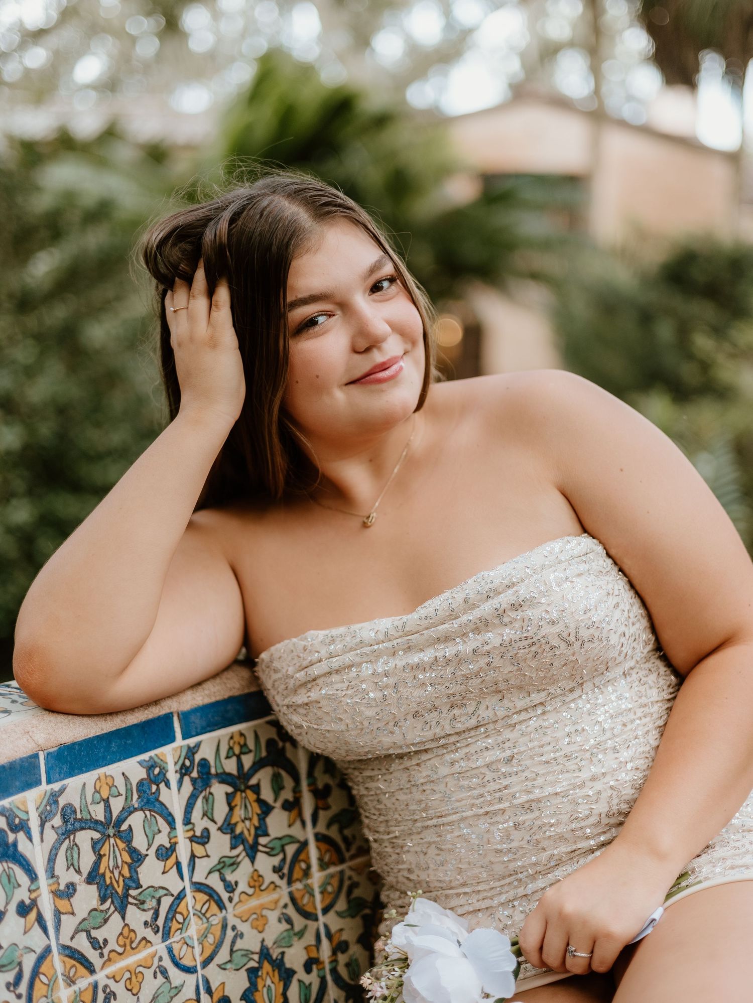 Five similarly styled close-up portraits showcase a person in a shimmering strapless dress posed against an ornate blue patterned wall.