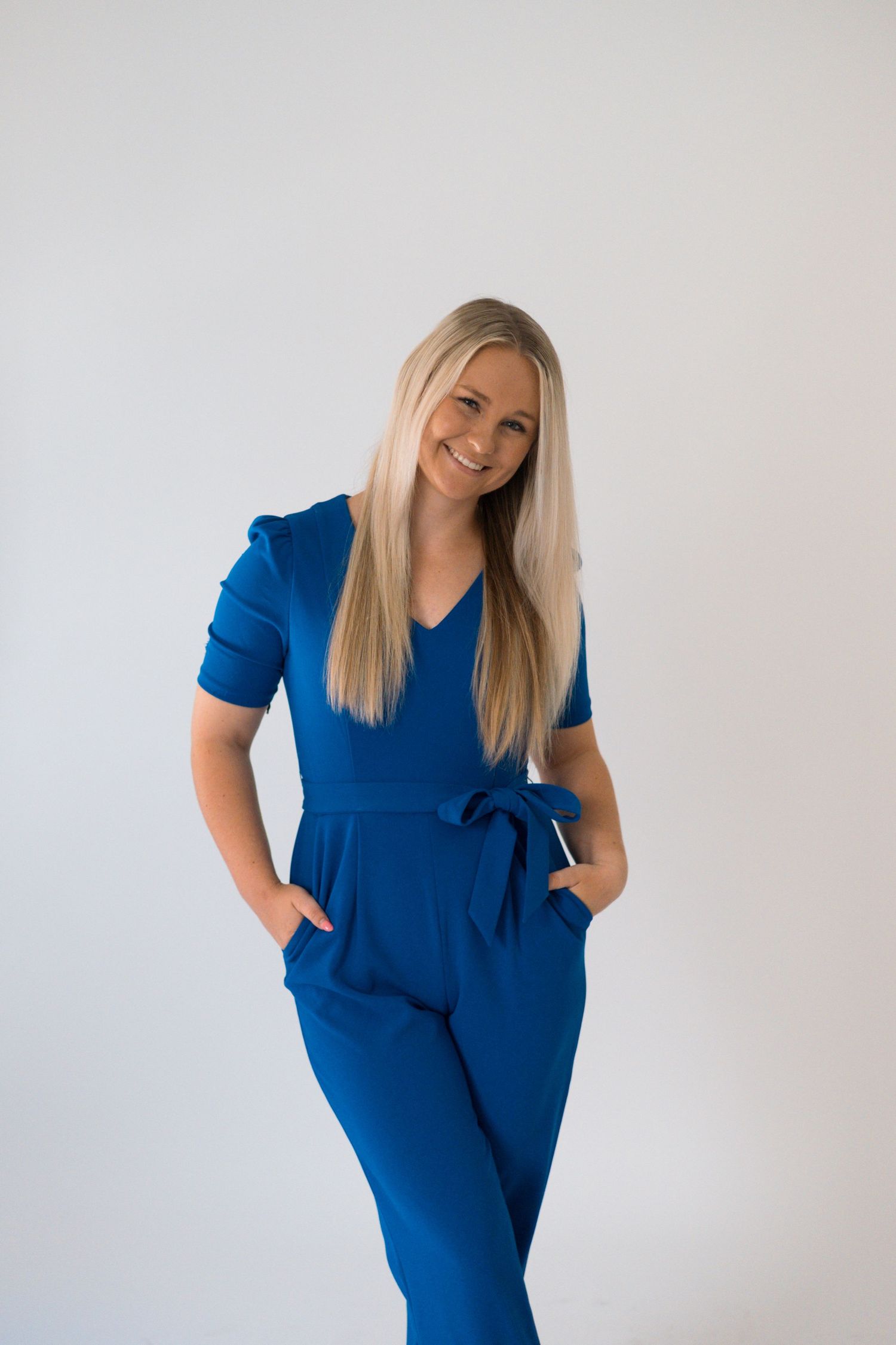 Studio fashion shoot showcasing a royal blue dress against a clean white backdrop.