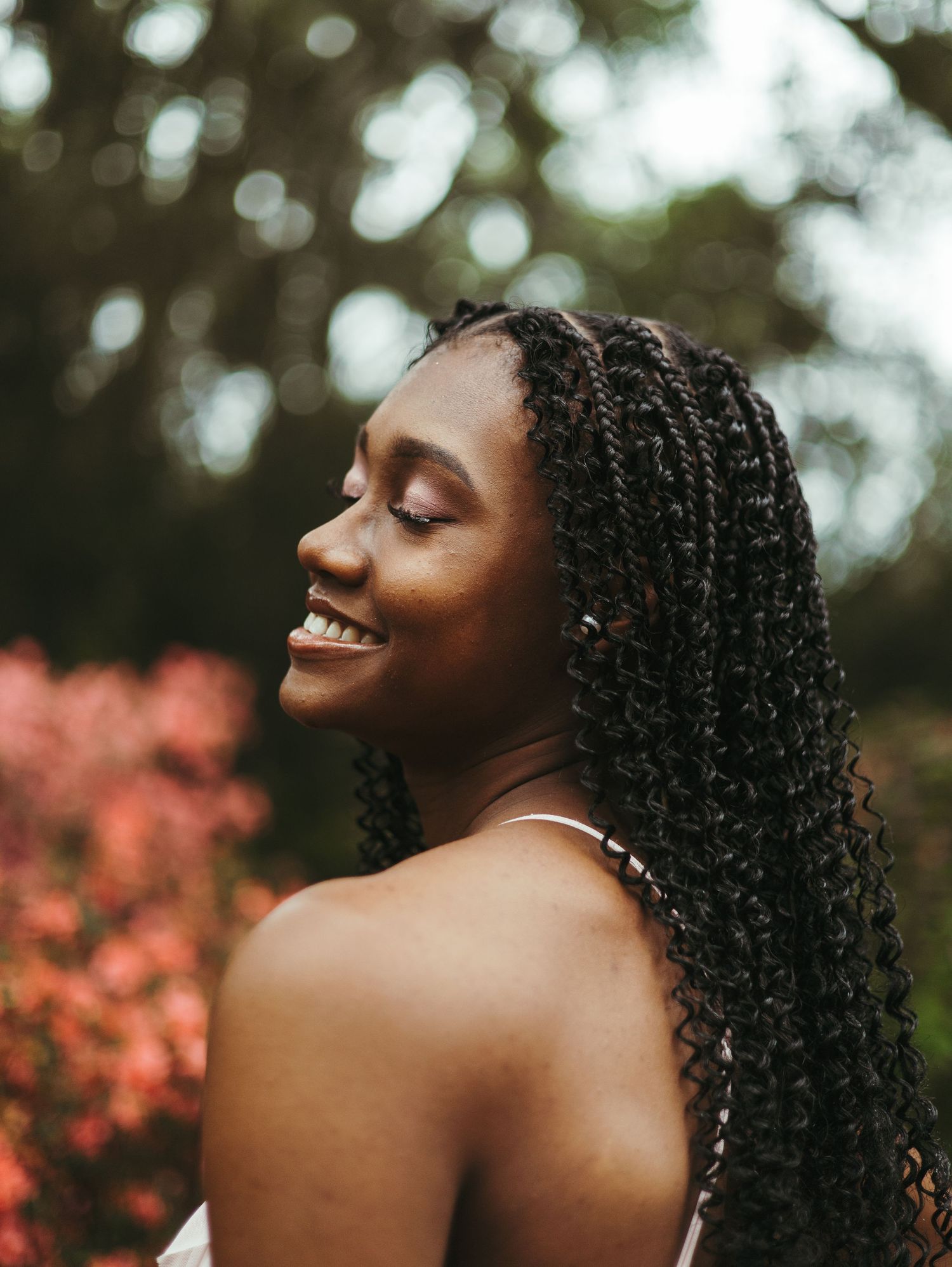 Natural light portrait with bokeh background and pink flowers.