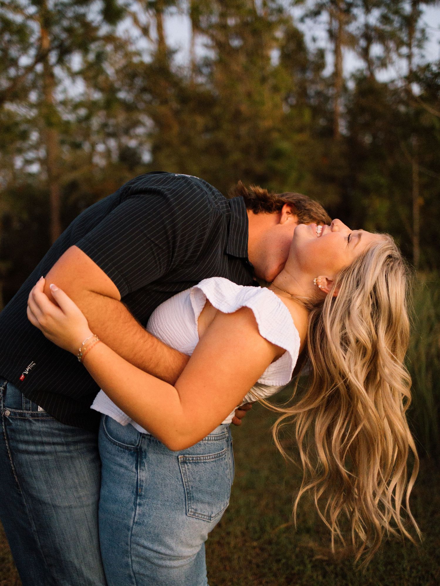 Romantic dance sequence showing a couple in casual attire dipping and embracing against a pine forest backdrop.