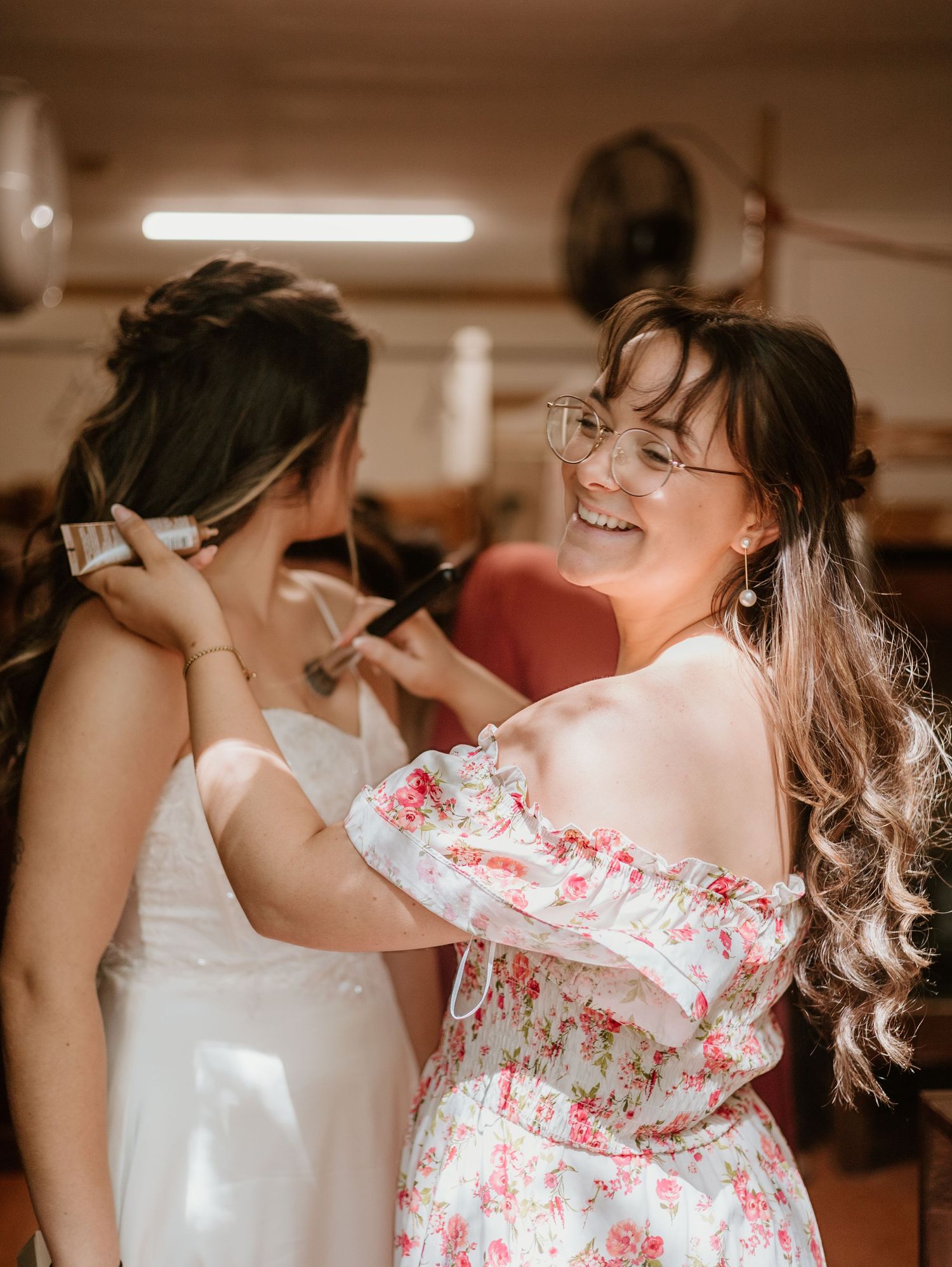 Behind-the-scenes moment of wedding dress preparation with floral details.