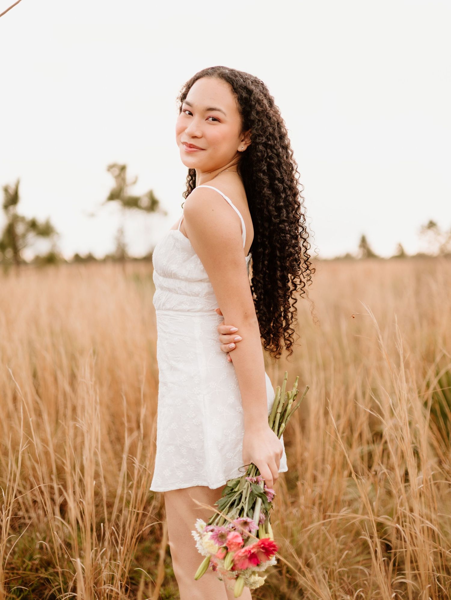 Natural outdoor portraits in wheat field with white top capturing candid moments.