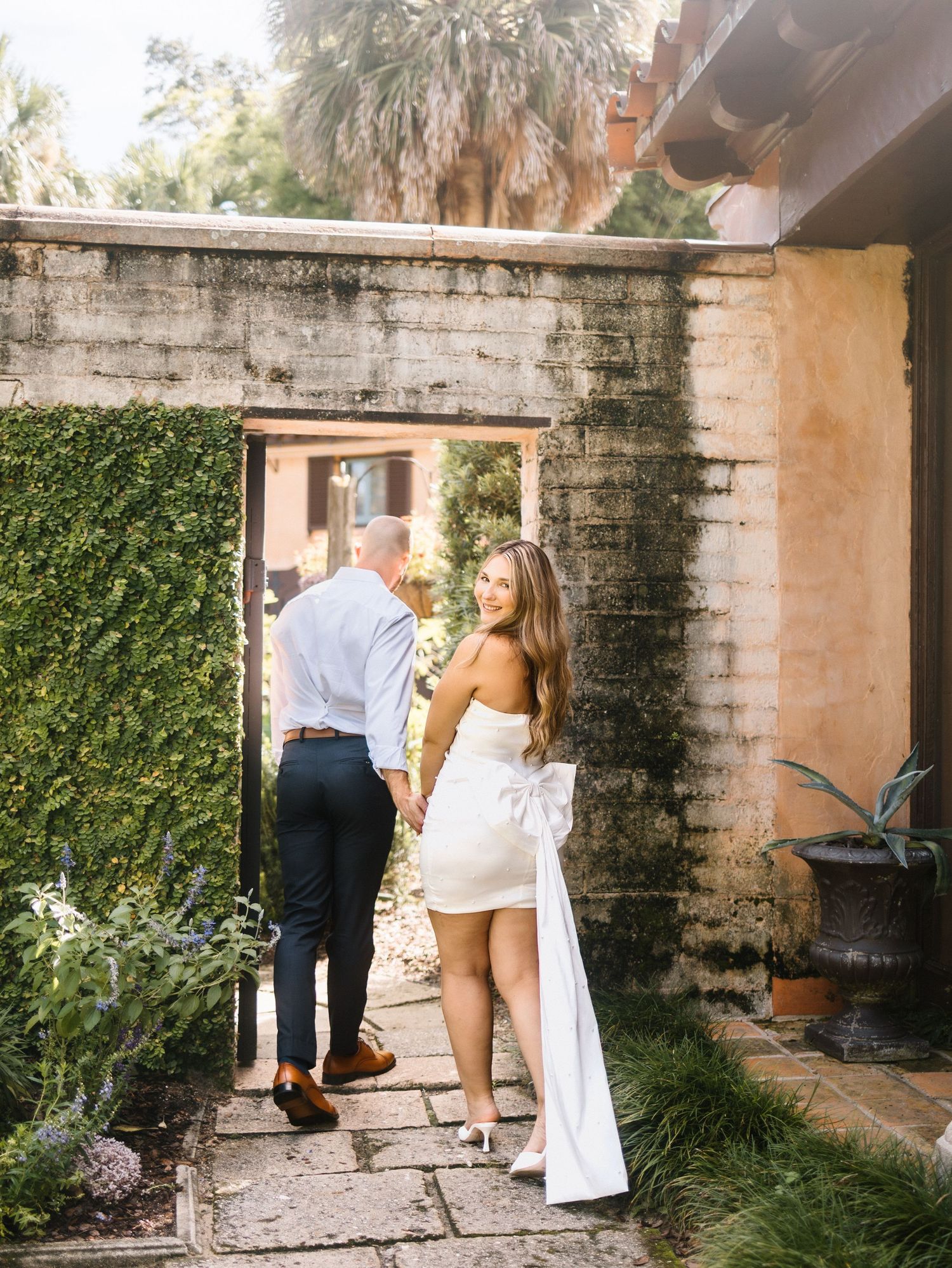 A series of romantic wedding day portraits captured in an outdoor garden courtyard setting with stone walls and ivy.