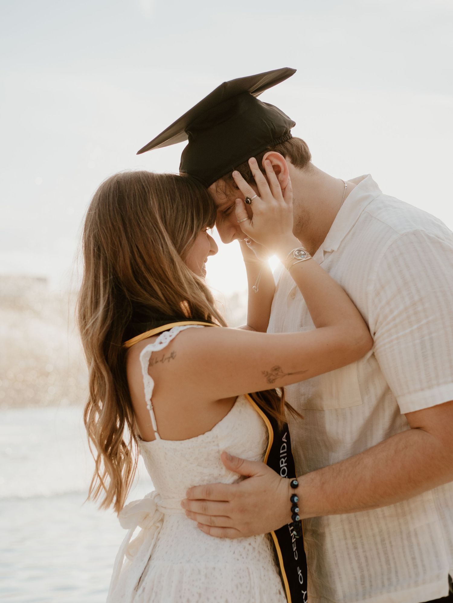 Romantic beach engagement photos at sunset with soft backlight.