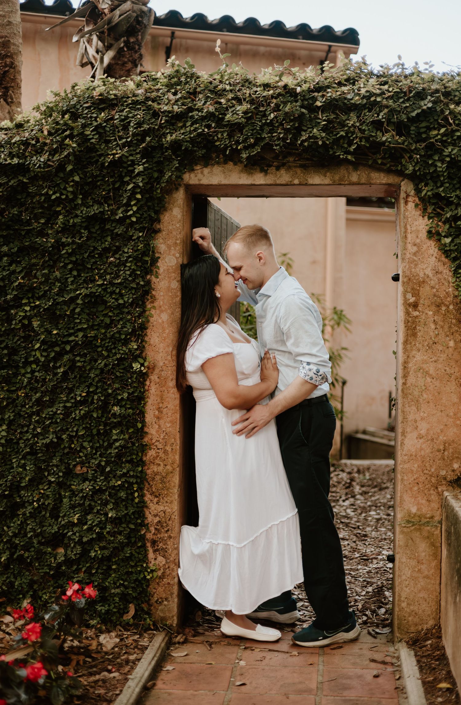Intimate couple photographs in front of an ivy-covered doorway at historic venue.