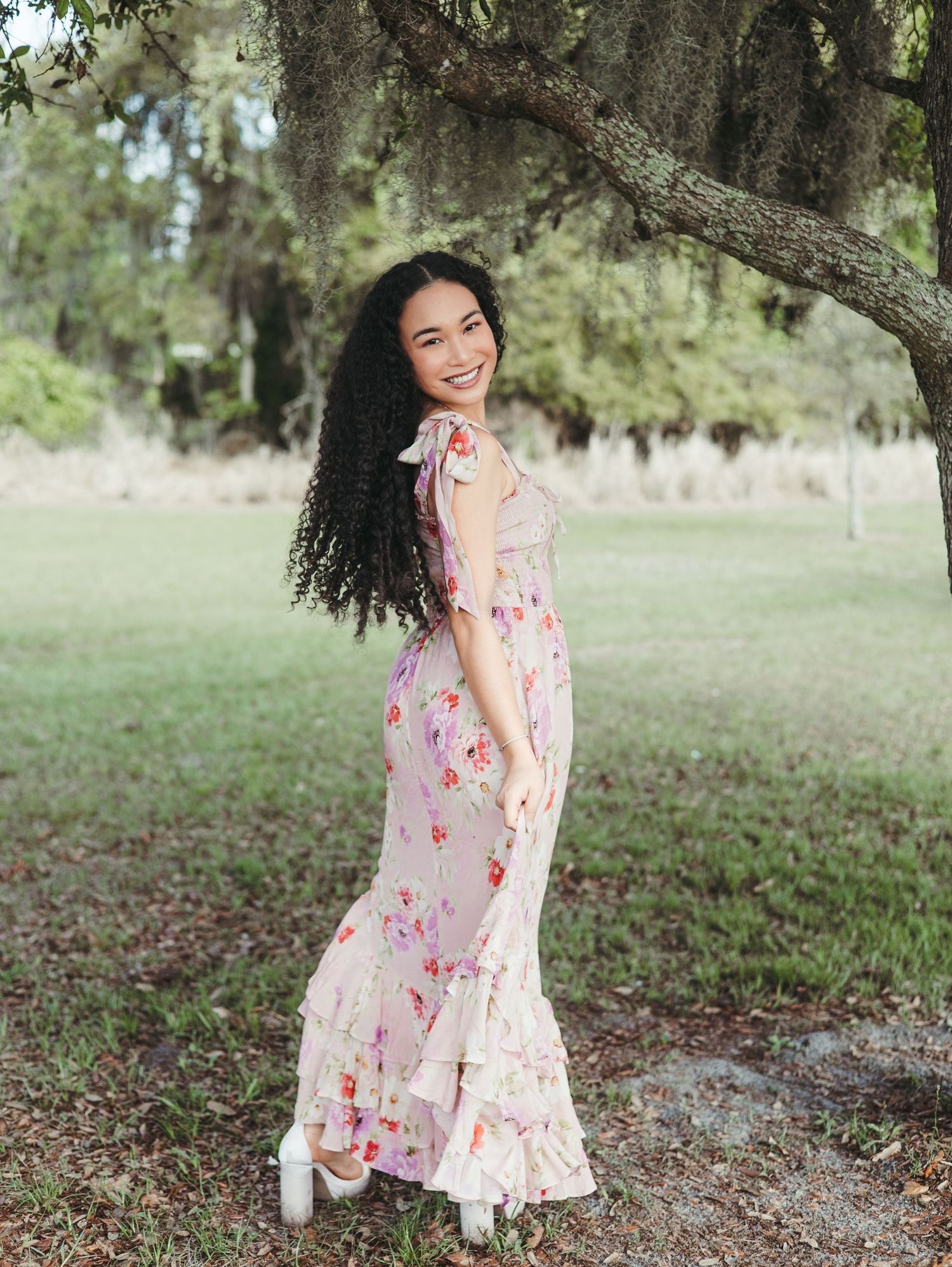 Lifestyle portraits under Spanish moss trees wearing floral pink dress.