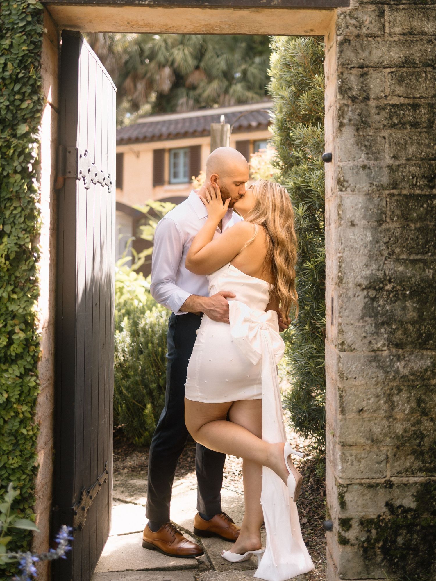 Engagement photography session between white columns showing tender romantic moments.