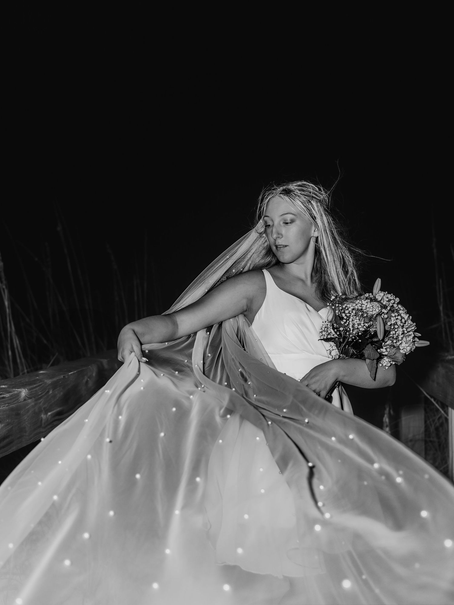 Artistic black and white photos of a flowing wedding dress with twinkling lights.