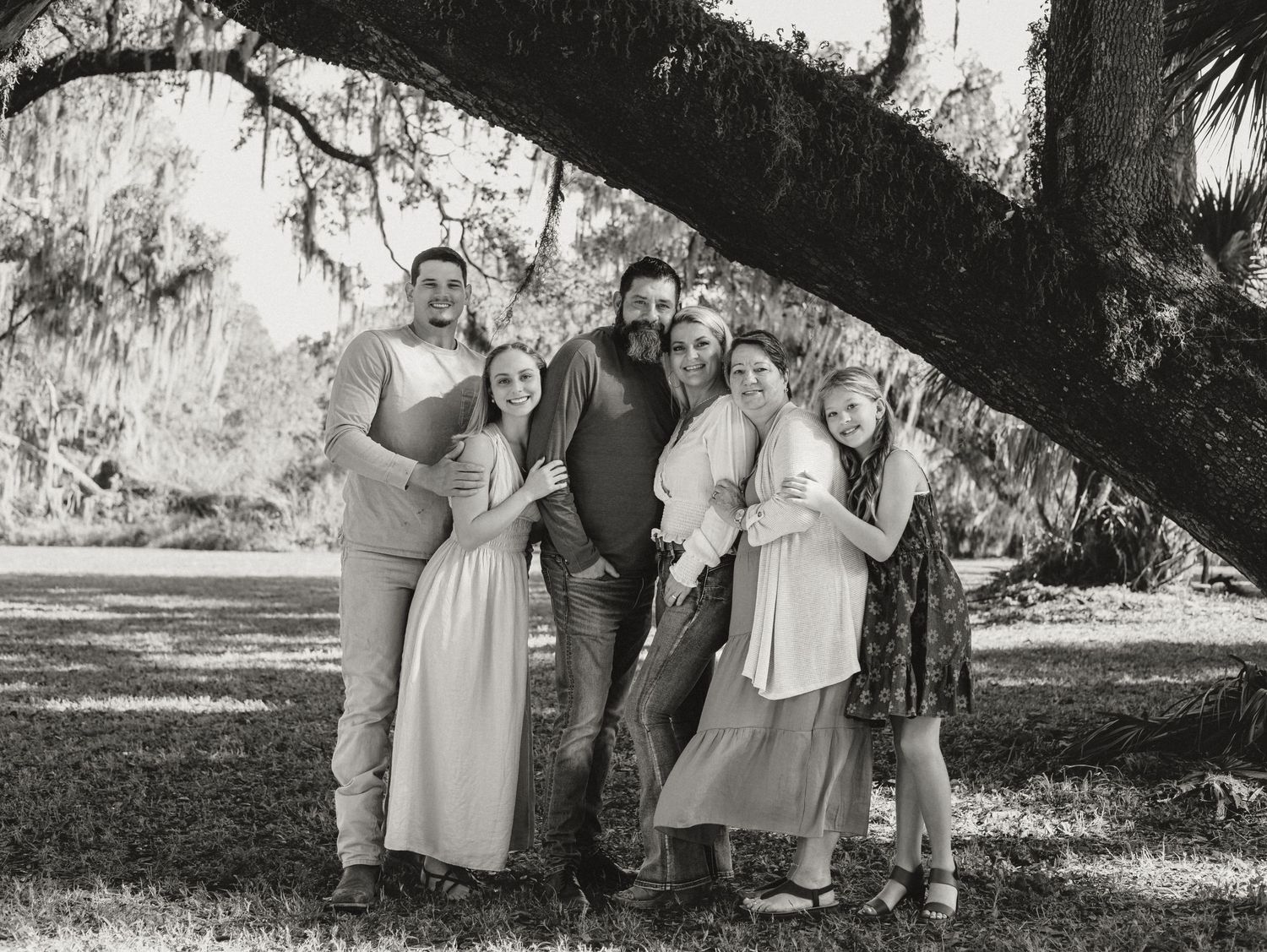 A black and white photo collage shows candid moments of people spending time together outdoors under trees.