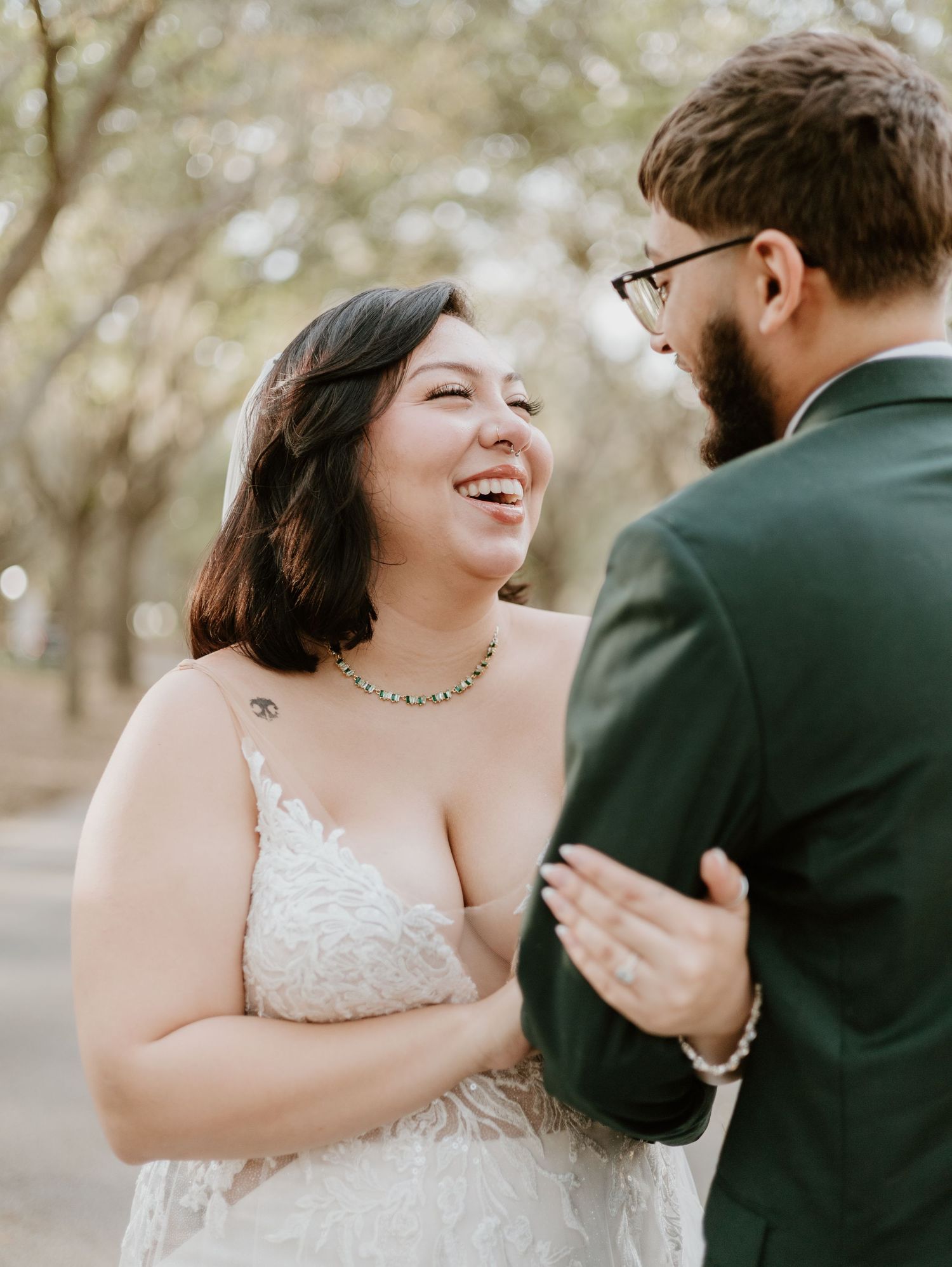 A couple shares a heartfelt moment laughing together outdoors during a wedding photo session.