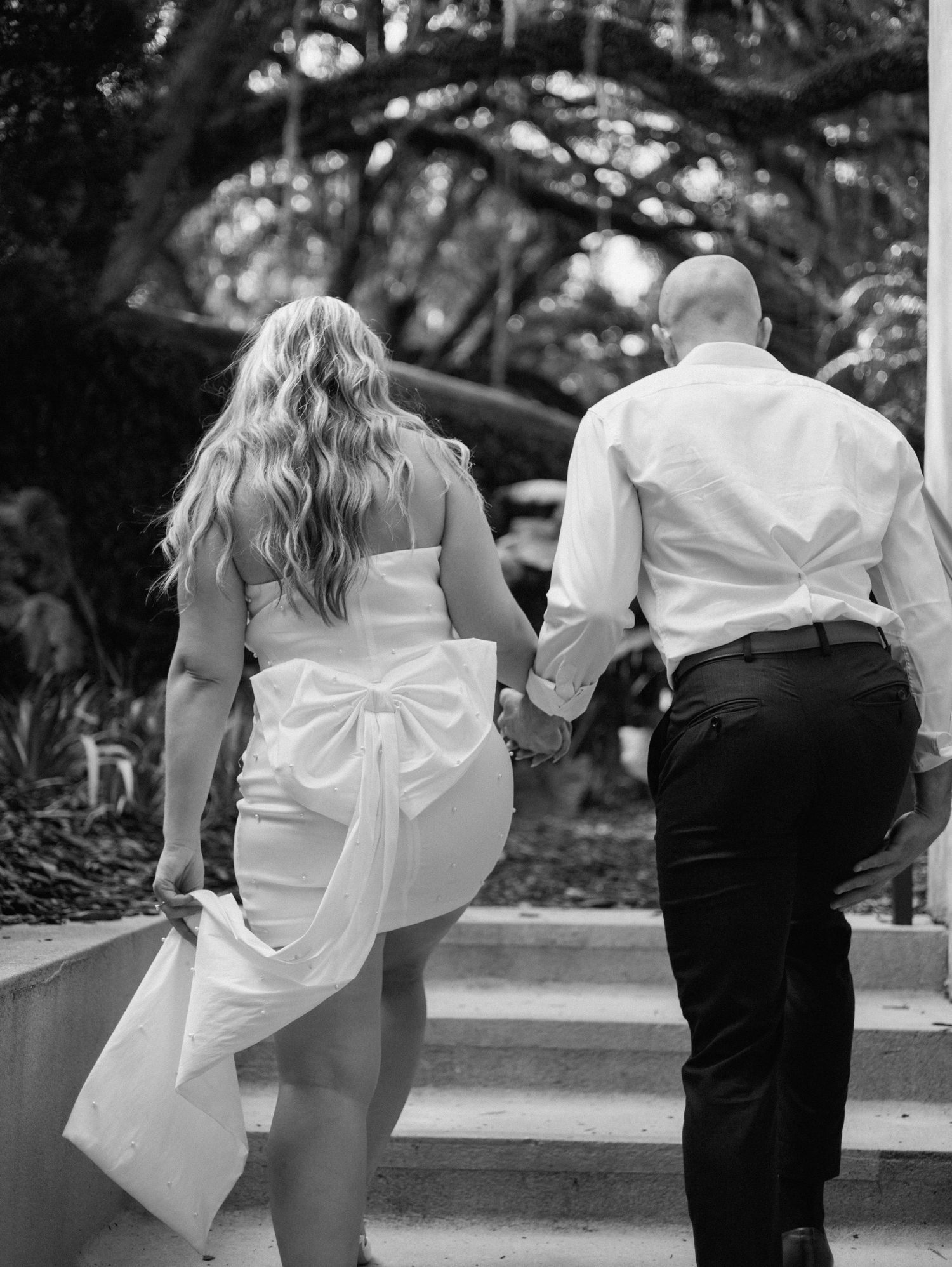 Playful sequence of couple walking and twirling in formal attire outdoors.