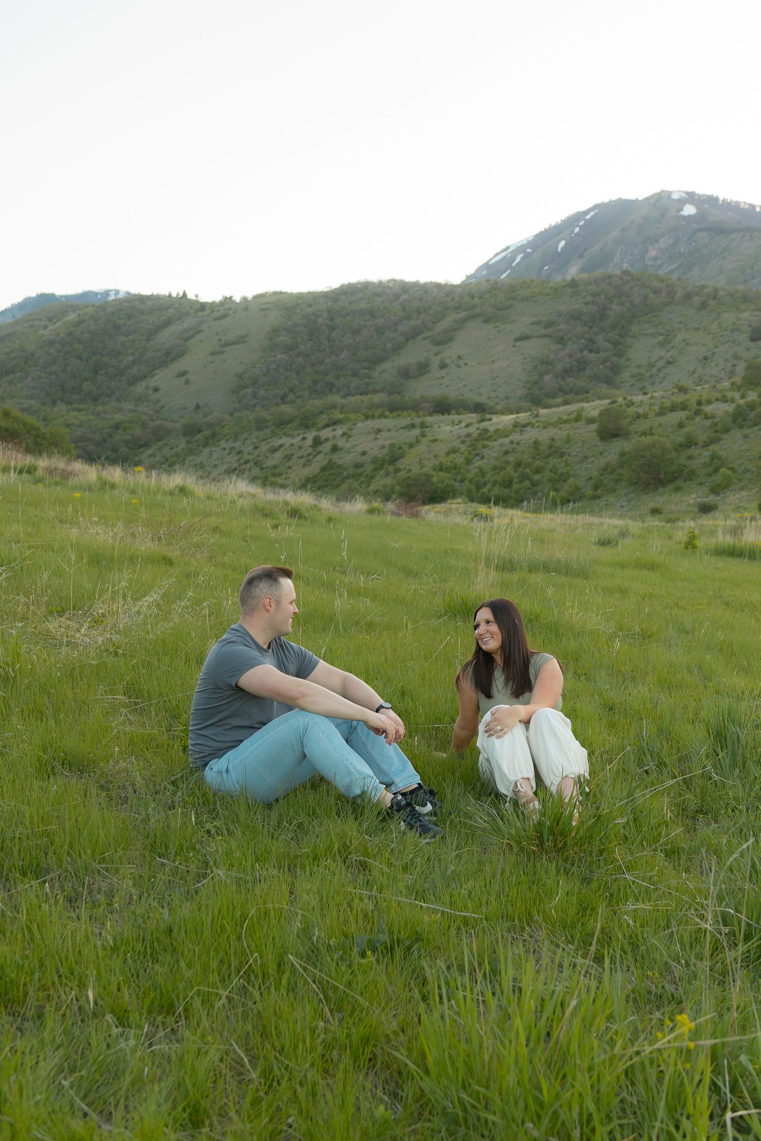A couple sitting together in a green field