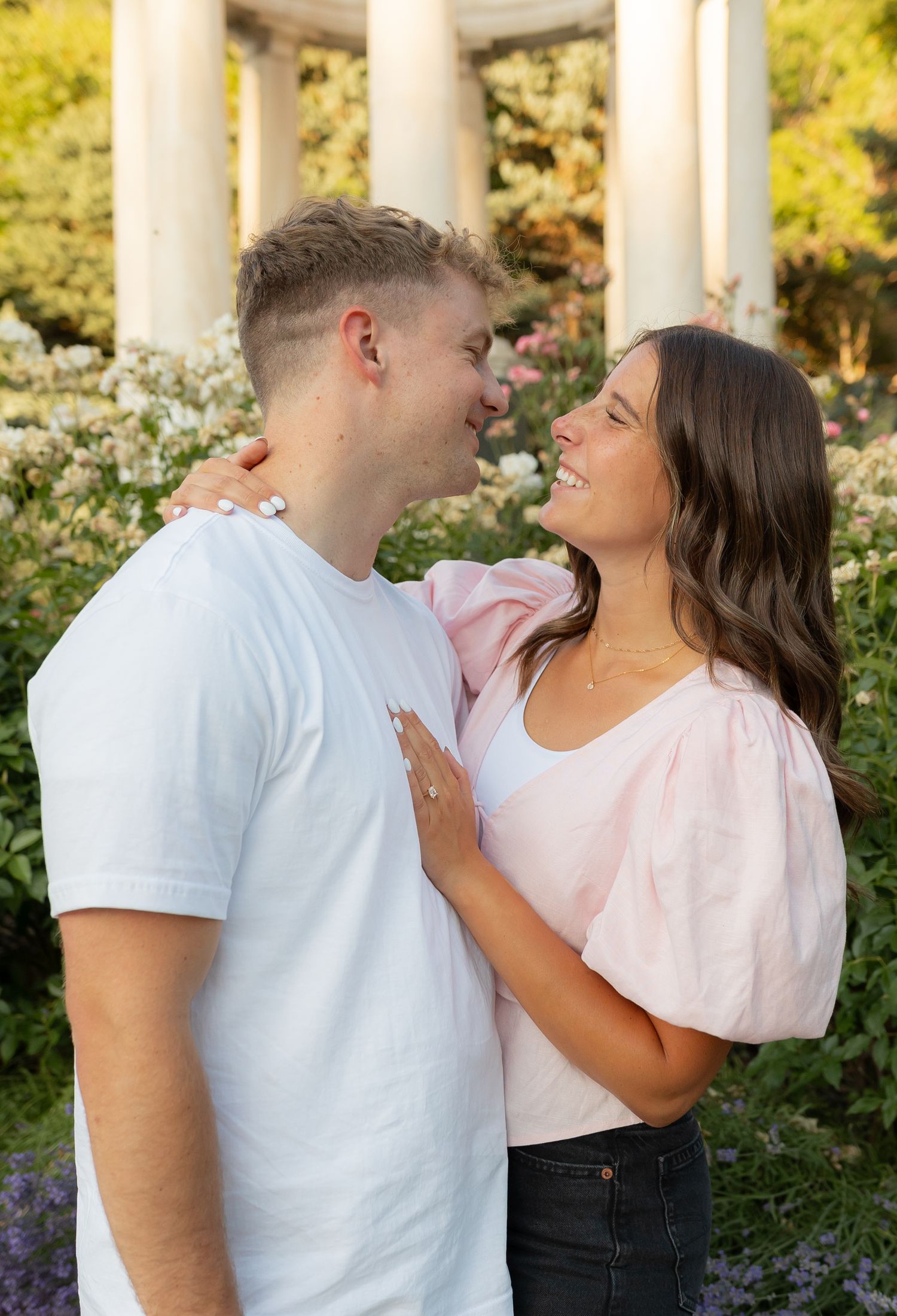 An engaged couple smiling at each other