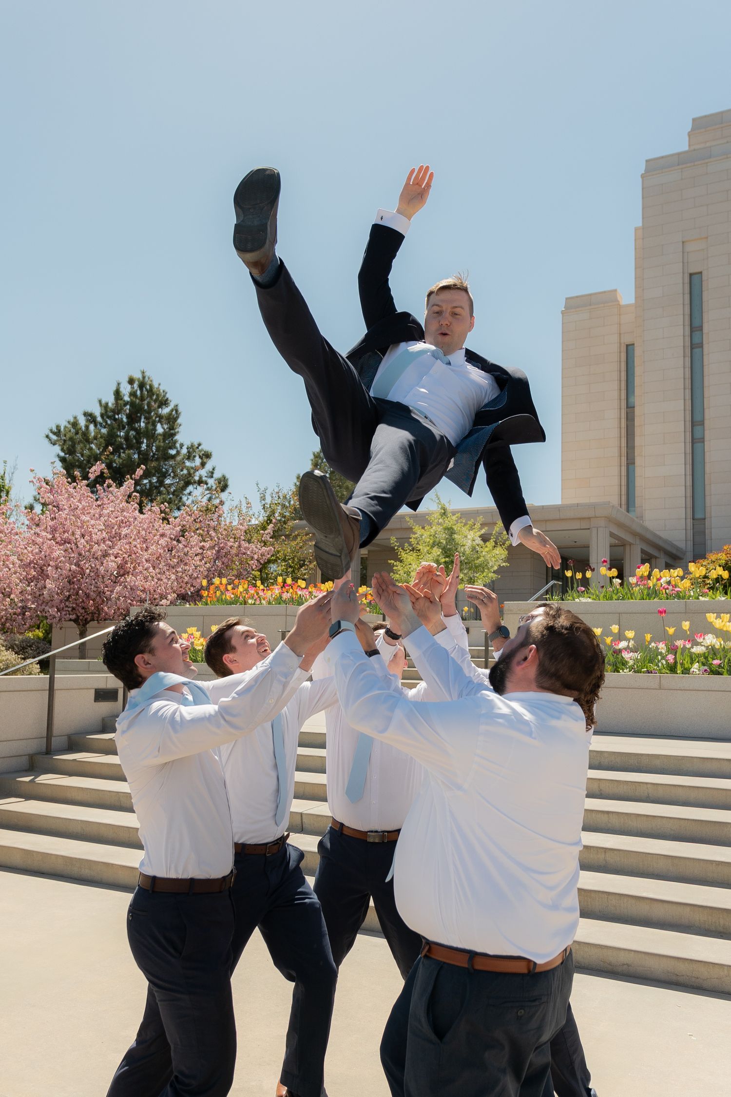 A groom being thrown into the air by his groomsmen