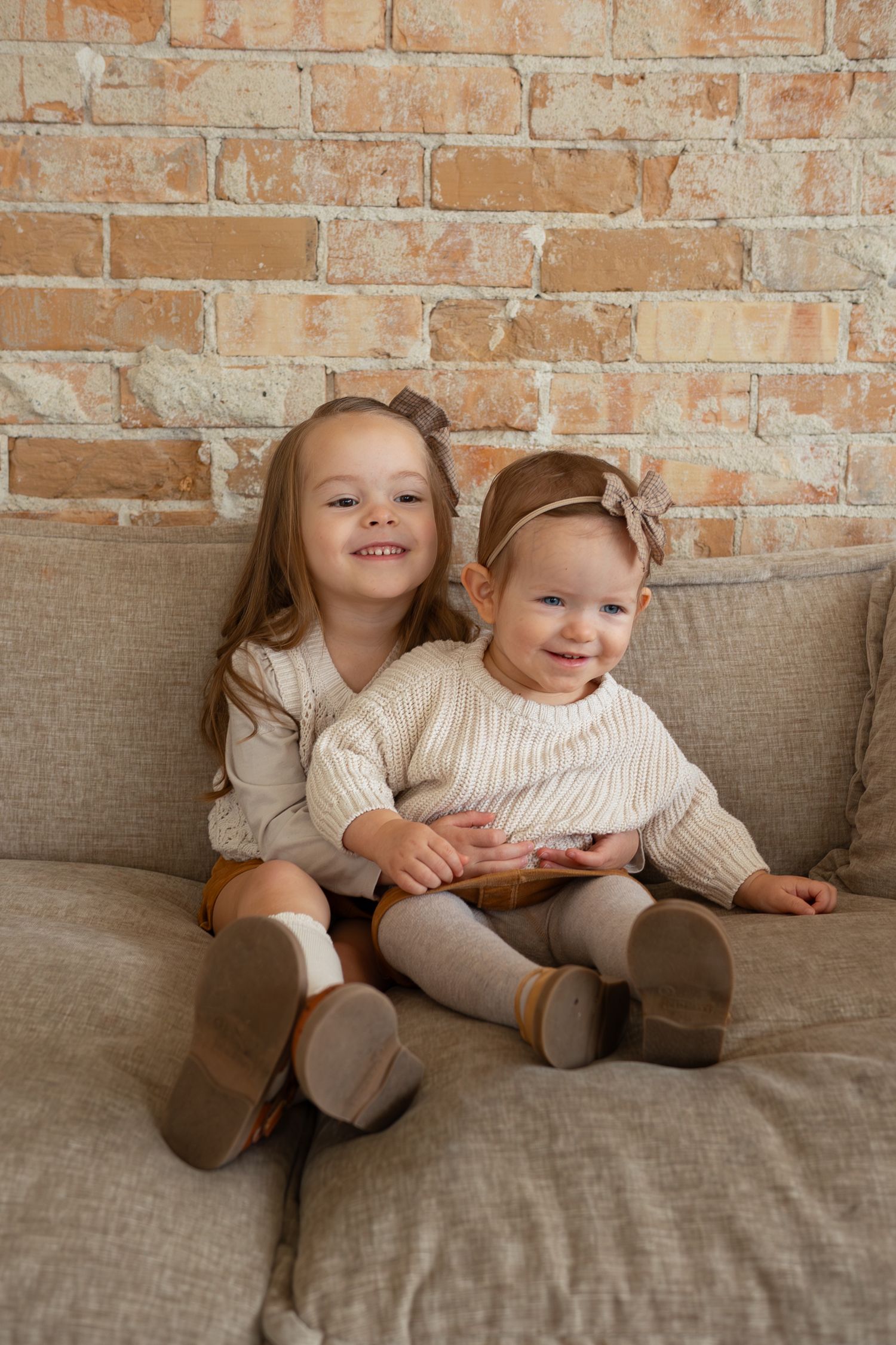 Family photo of two young sisters on a couch