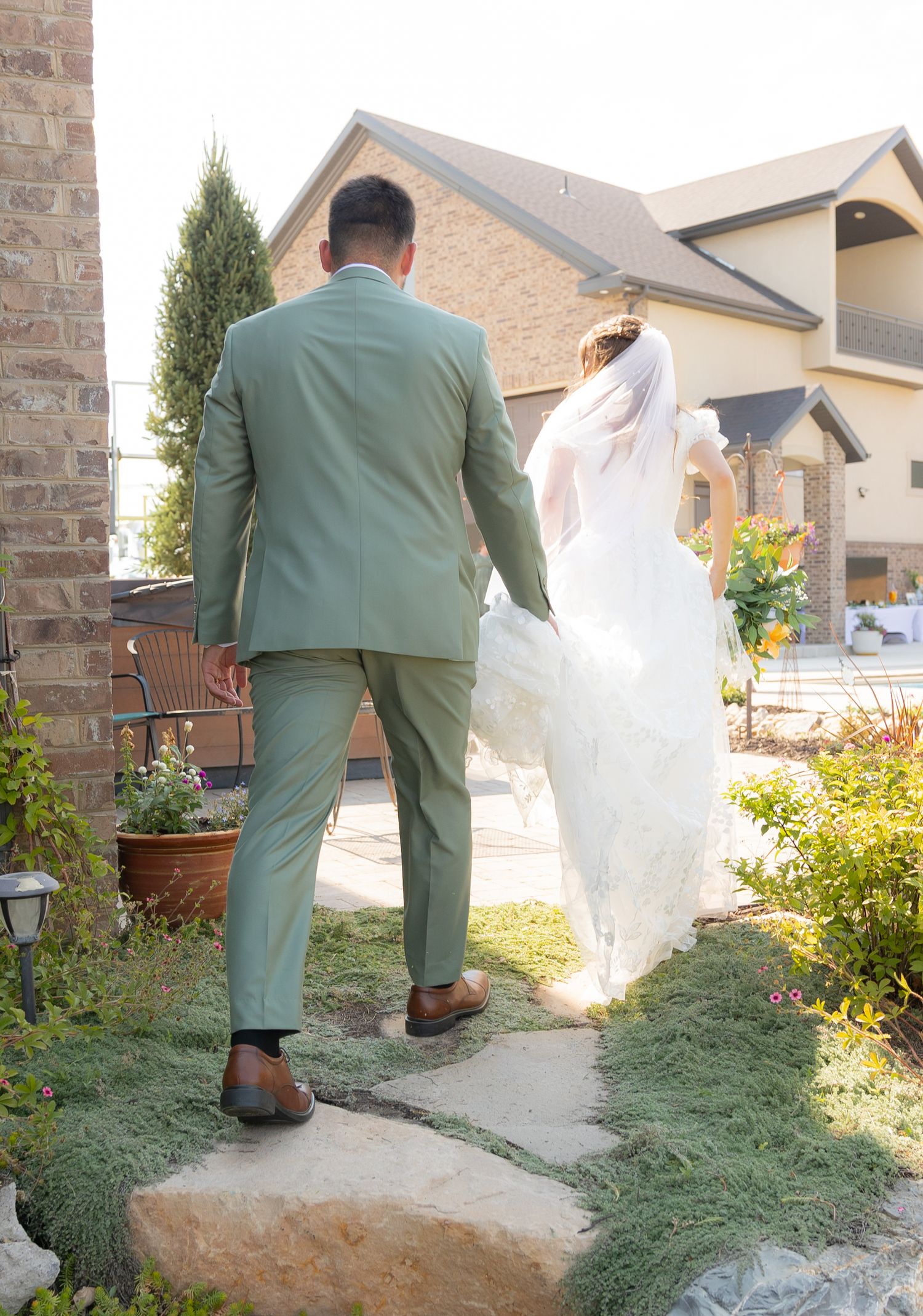 A groom carrying his bride's dress train