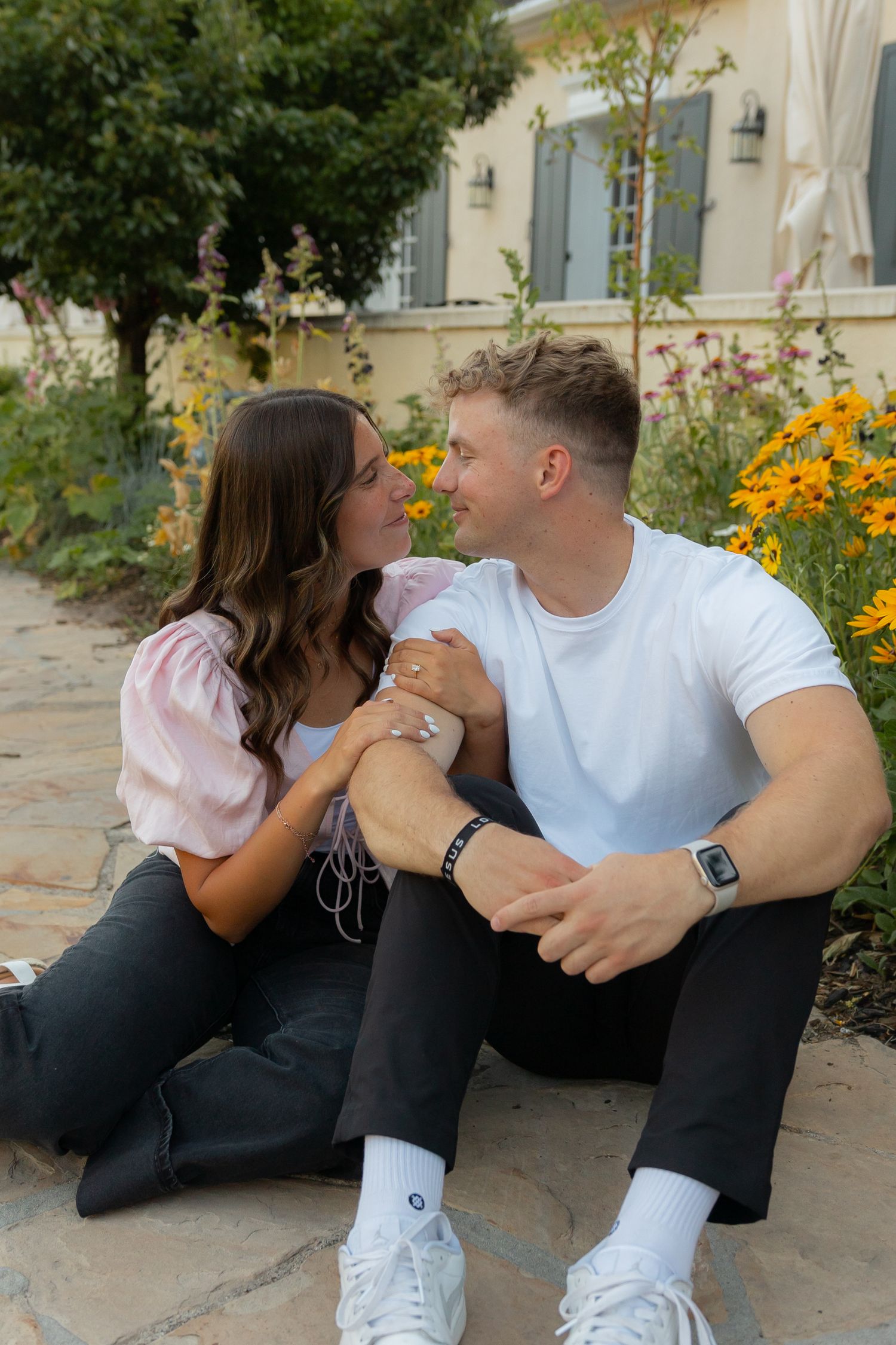 A couple sitting together in front of flowers