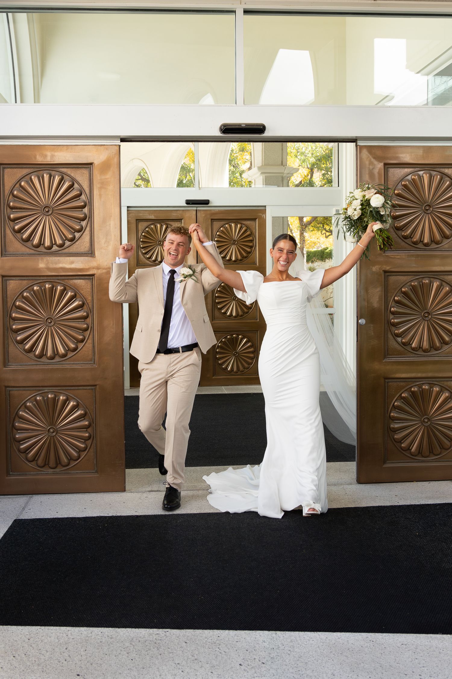 A bride and groom exiting the Bountiful Utah Temple